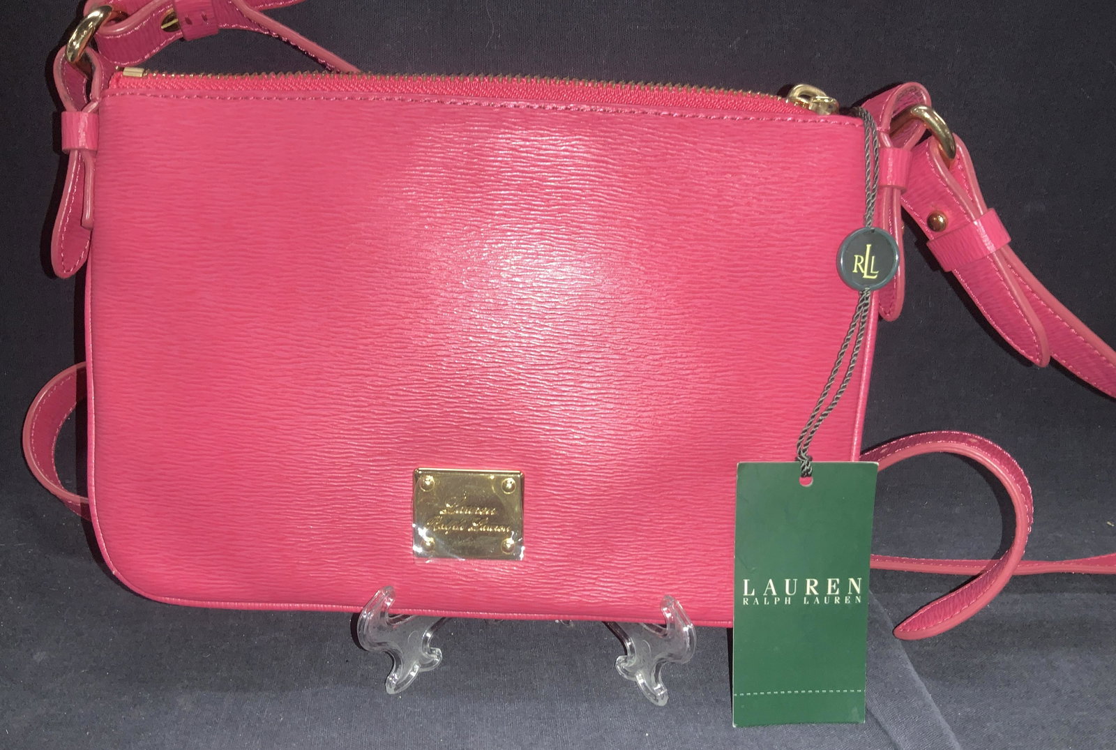 Ralph Lauren Newberry Pink Leather Bag, NWT: Signed Lauren Ralph Lauren â€˜Geraniumâ€™ color Newberry Flat Crossbody bag, possibly leather, unmarked fabric. Adjustable strap, Signed gold tone hardware, brown cotton fabric lining with Ra