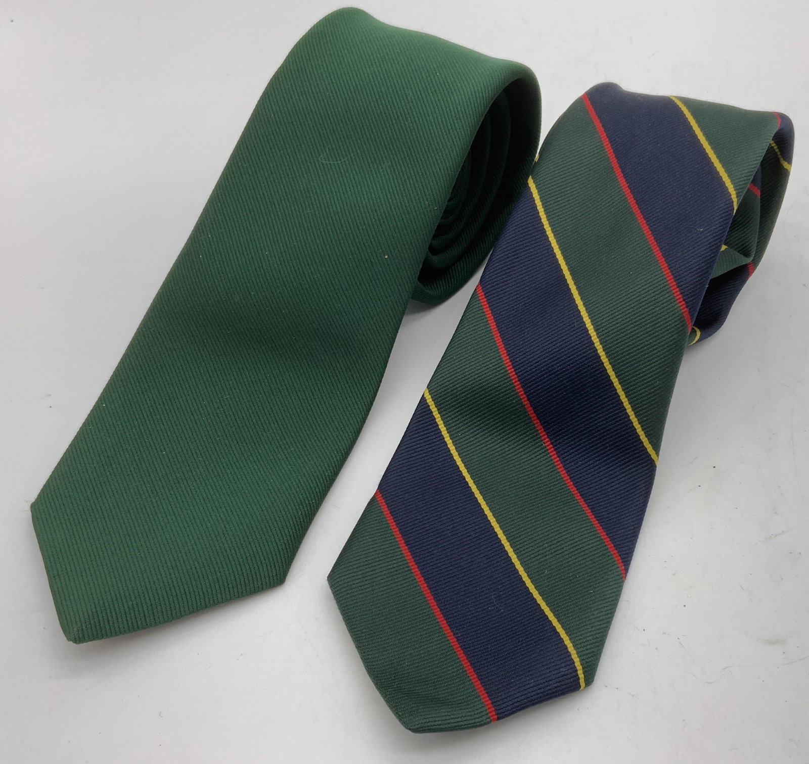 Lot 2 Vintage Green Neckties: Labels read as â€˜Geoffrey Beene Imported 100% Polyesterâ€™, and â€˜Austin Scott, 80% polyester, 20% silkâ€™. Surface wear present, consistent with age and use. Largest piece measure