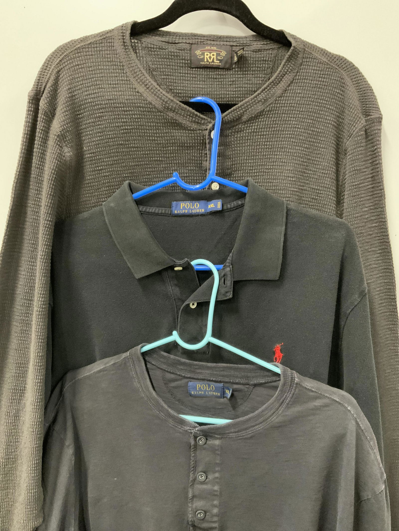 POLO BY RALPH LAUREN Lot 3 Long Sleeve Polo Shirts: POLO BY RALPH LAUREN Lot 3 Long Sleeve Polo Shirts, tag read ‘POLO BY RALPH LAUREN…XXL… 100% COTTON… grey and two tones of black… Embroidered RALPH LAUREN Polo insignia. Property of Central