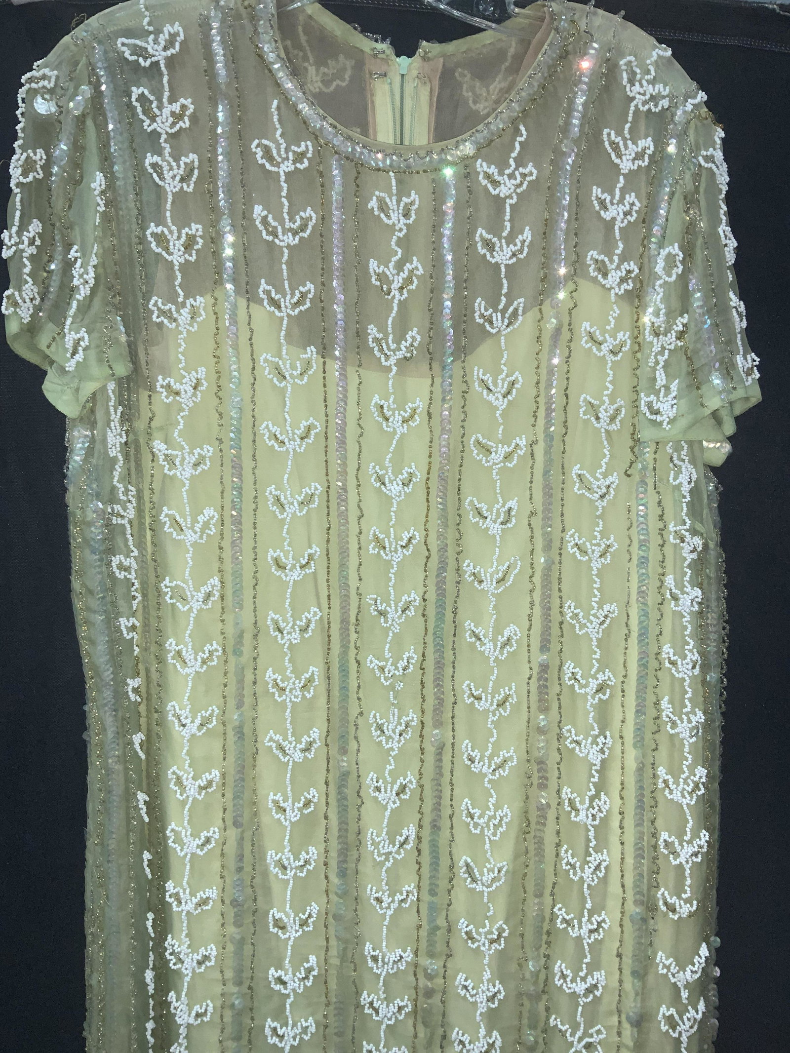 Mid century Bead Short Sleeve Dress: Green dress with white beading and clean rainbow sequins. Short sleeve. Lined. Zipper on backside. Waist 40 in. Straight tunic style, slip dress underneath. 38 in. Long. A few loose beads. Weighted dr
