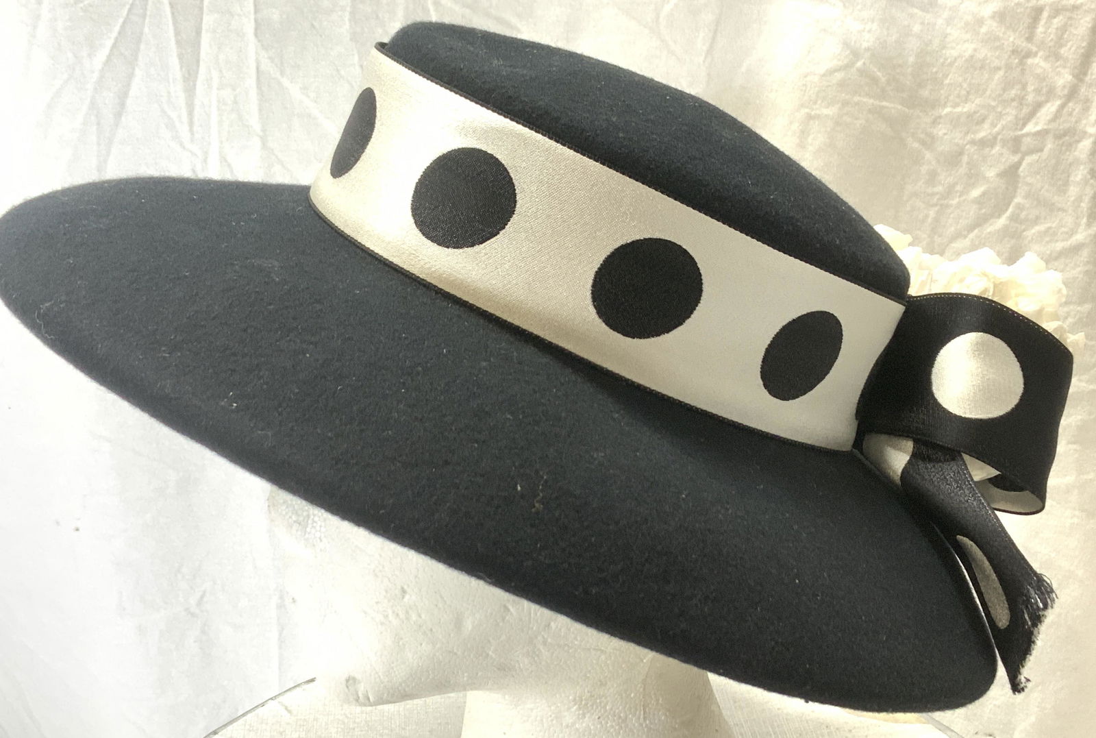 Posh Spectator Hat in Bergdorf Goodman Box: Wide brim black has with silver and black polka dot ribbon wrapped around center extending into a bowl . Possibly wool fabric. Brim 3.75 in. Wide and slighting curves down and inward. Total width of h