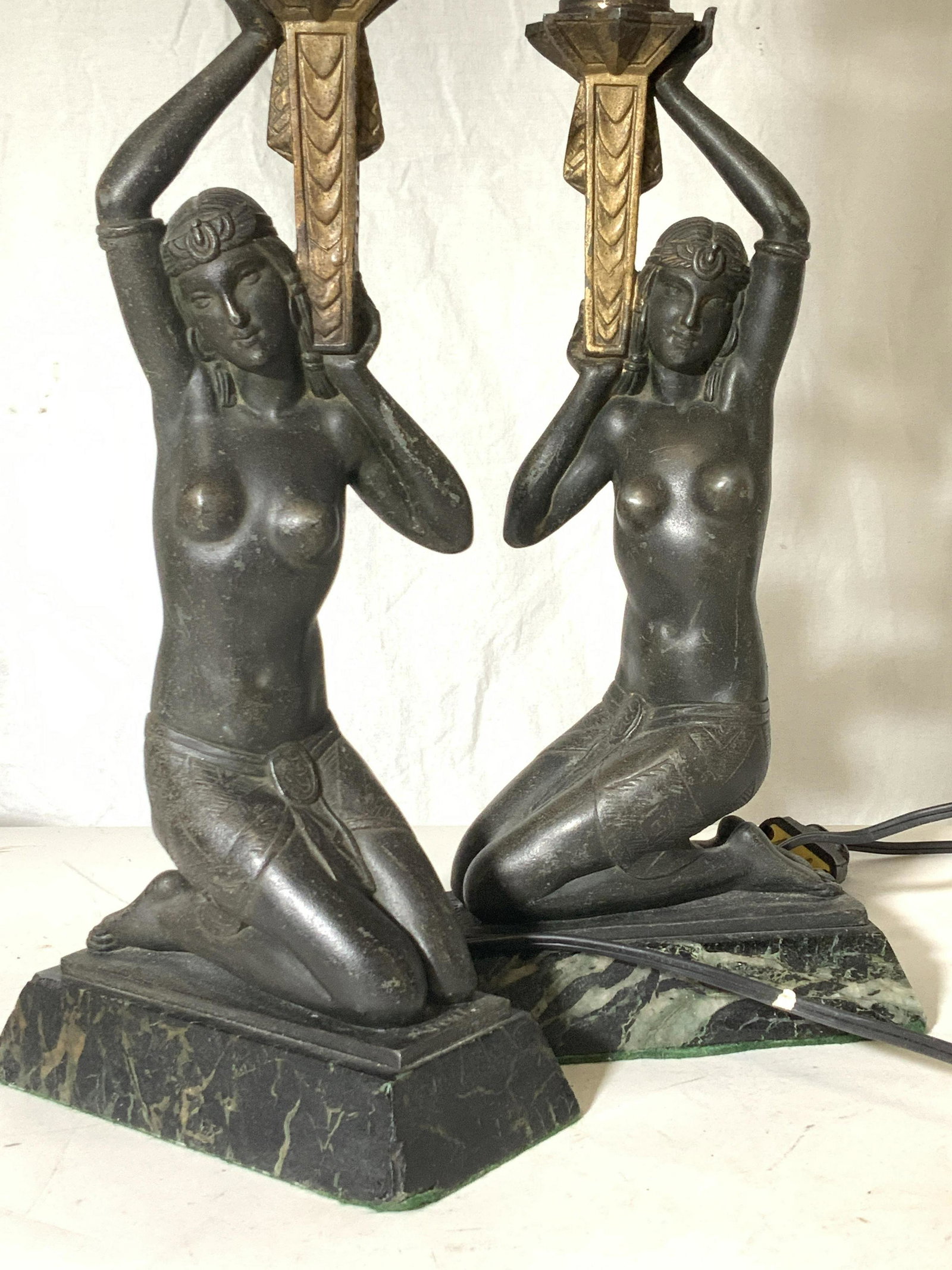 Pair Art Deco Egyptian Bronze Toned Lamp signed: Bronze toned metal, Egyptian Nudes gold torch. Set on trapezoid marble base. mid century Art Deco Egyptian lamps . Not tested. One pillar needs fixing. Both with light harps and brass finials. Wear ex