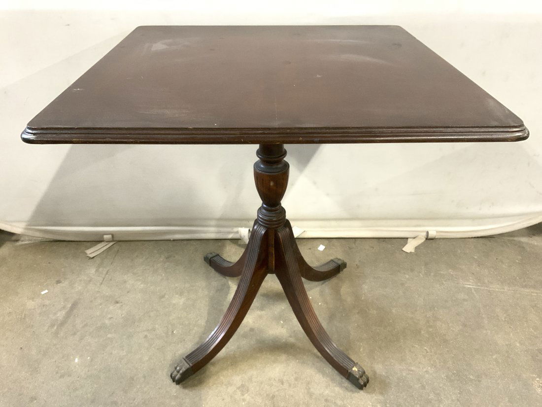 Vintage Carved Wooden Pedestaled Tilt Top Table: Table is vintage possibly antique. Piece is wooden with 4 metal talon feet. Table has pedestaled base. Table has tilting top with rounded square shape. Piece measures approx 28 inches tall 27 inches s