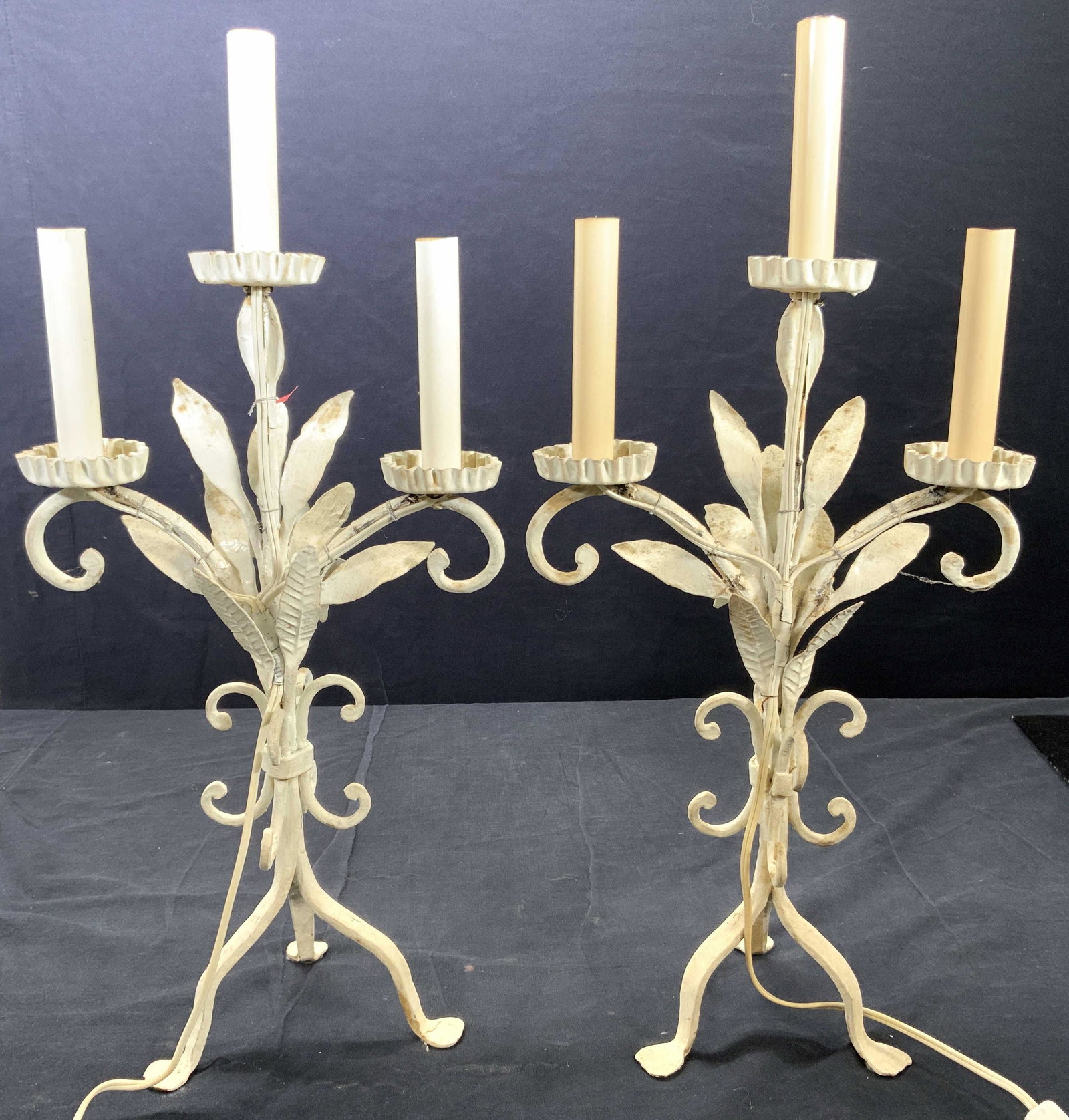 Vintage 3 Arm Metal Candelabra Style Sconces: Sconces are vintage and metal. Each piece has 3 arms with candlestick style bulb sockets at ends. Each piece has 3 feet. Pieces have C curve detail & floral and leaf detail. Each measures approx 22 in