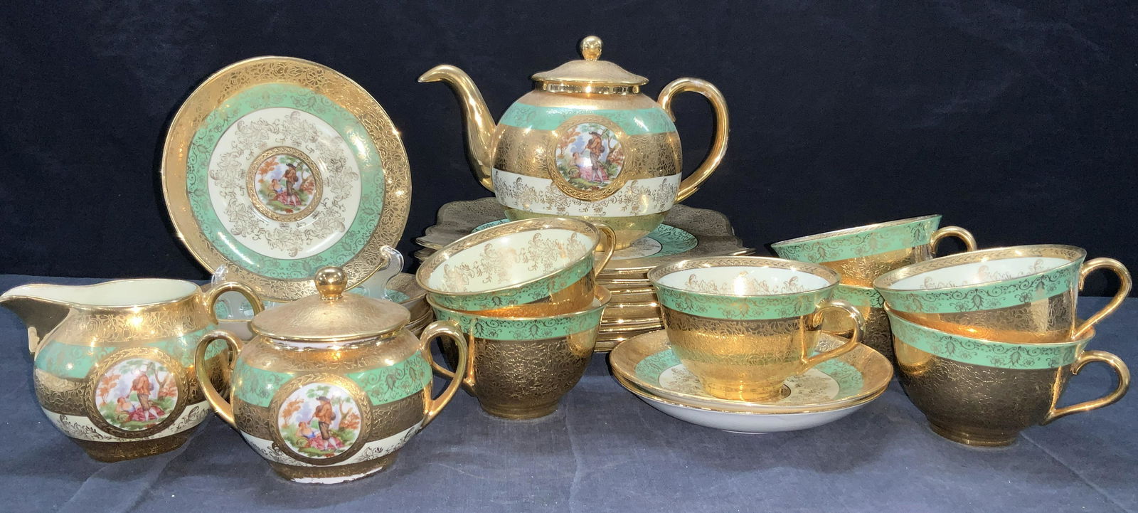 26 LONGTON Bone China Tea Set W 24 Karat Gold Gilt: 26 PCs Bone China tea set consisting of 7 cups, 8 saucers (5.5 inches wide), 1 sugar bowl, 1 cream pourer, 8 dinning plates (8.75 x 8.75 inches) and 1 tea kettle (6.75 inches tall) All are marked on u