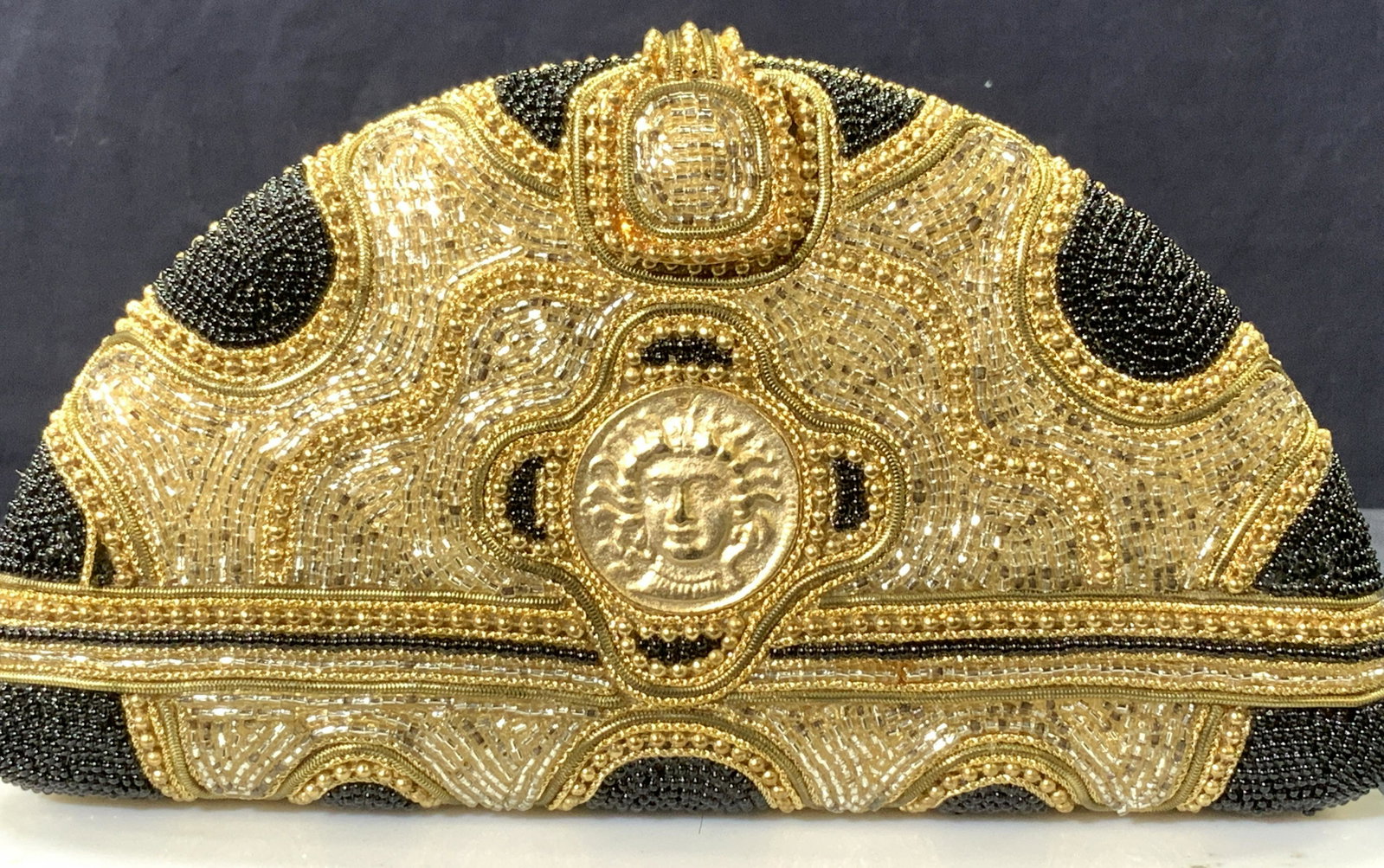 M&J HANSEN Hard Case Beaded Clutch/ Cross, Sgn: Luxury Vintage M & J Hansen Designs LTD Made in USA Beaded Clutch/ Shoulder bag/ crossbody bag. Hard case with goldtone hardware, silver, black and gold beads with center Medusa Face medallion. This i