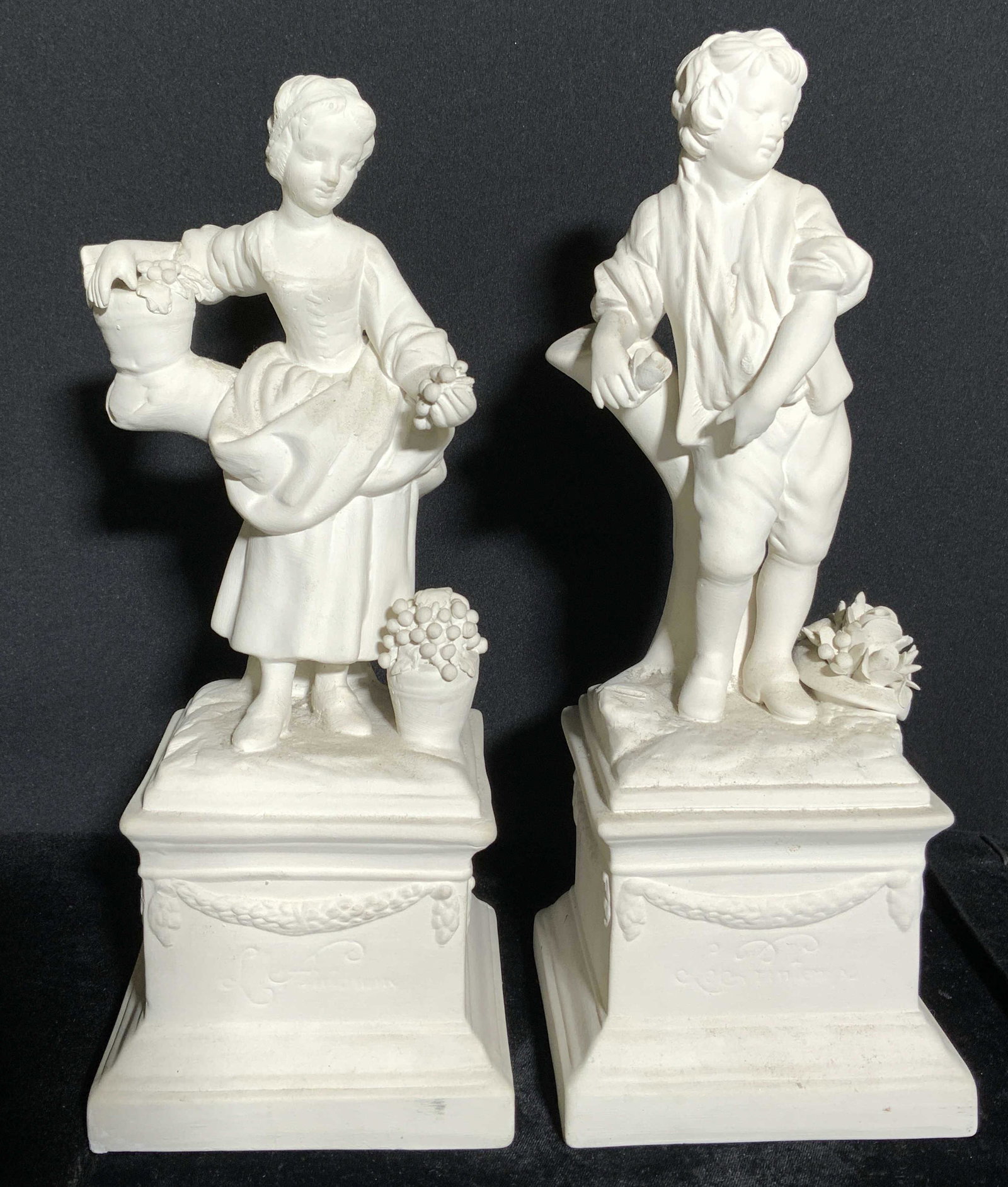 Lot 2 Male & Female Plaster Figures: Lot includes 1 male & 1 female figure. Each are white toned and appear to be plaster, possibly porcelain. One is inscribed LE PRINTEMPS the other is marked LE ANTOMNE. Each depict figures standing on 