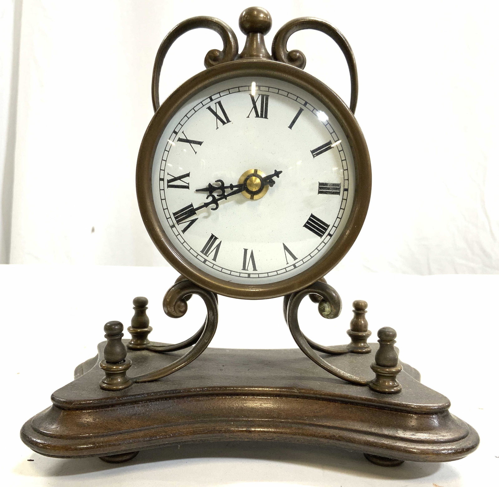 Vntg Metal & Wooden Mantel Clock: Clock is vintage. Piece has metal top & base which appears to be wood possibly veneer. Clock face is white with black toned Roman numerals. Piece measures approx 8 inches tall & wide 4.5 inches deep. 