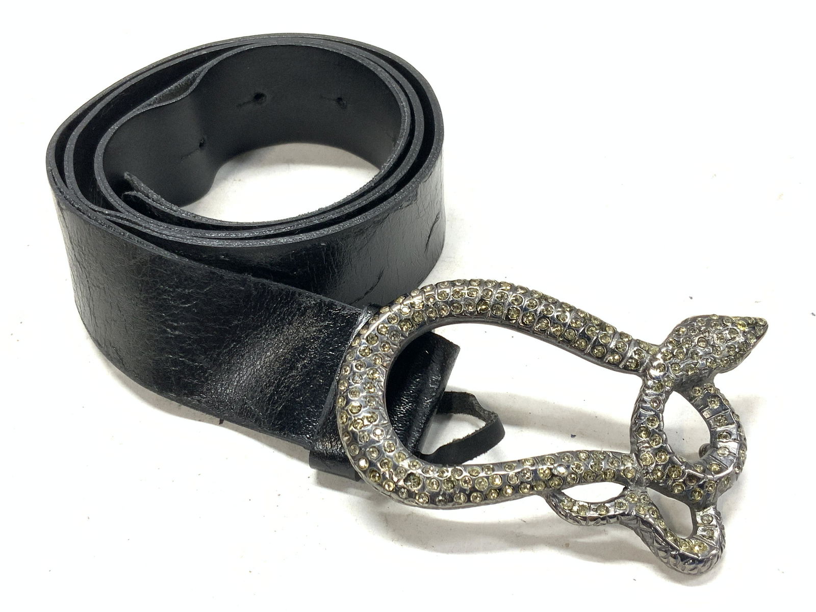 BLUMARINE Italian Leather Belt: Black leather belt with costume snake belt buckles. Buckle is encrusted with rhinestones. Marked on inner layer of belt is marked BLUMARINE Made in Italy. 44. Approximately 37 inches long. Wearing to