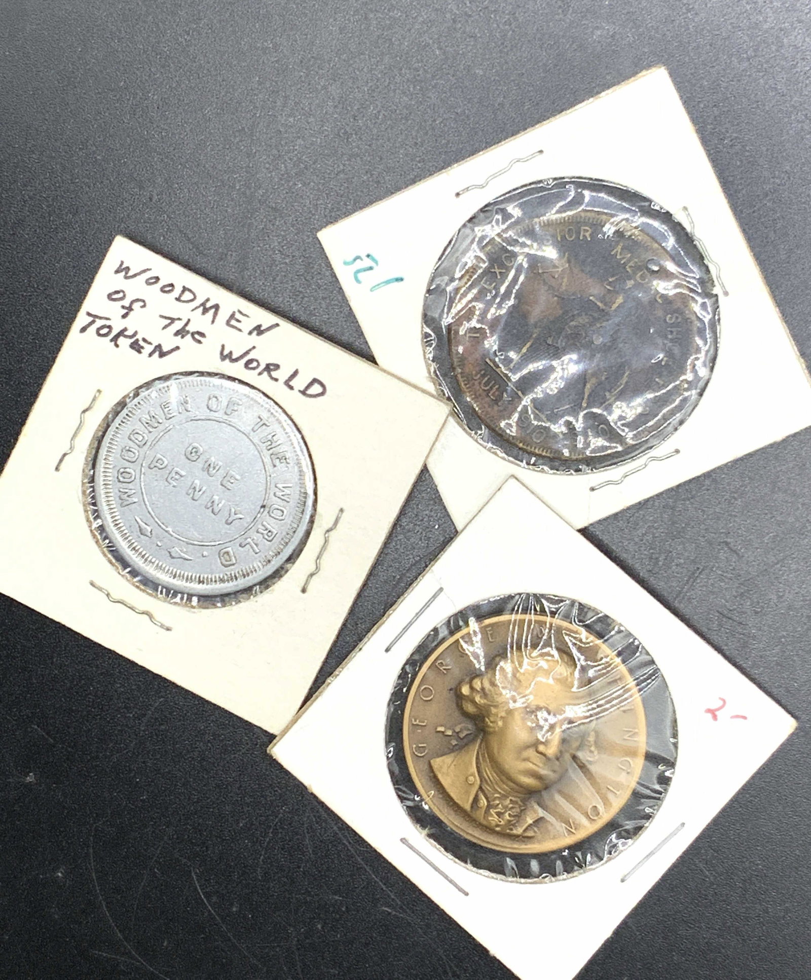Vintage Boy Scout, Woodsman of the World Coins: Group lot of 3 vintage coins. 1 silver toned coin marked Woodmen of the World, one penny, with the tails side depicting a dove flying over a log with an axe next to it. 1 copper toned coin marked Geor