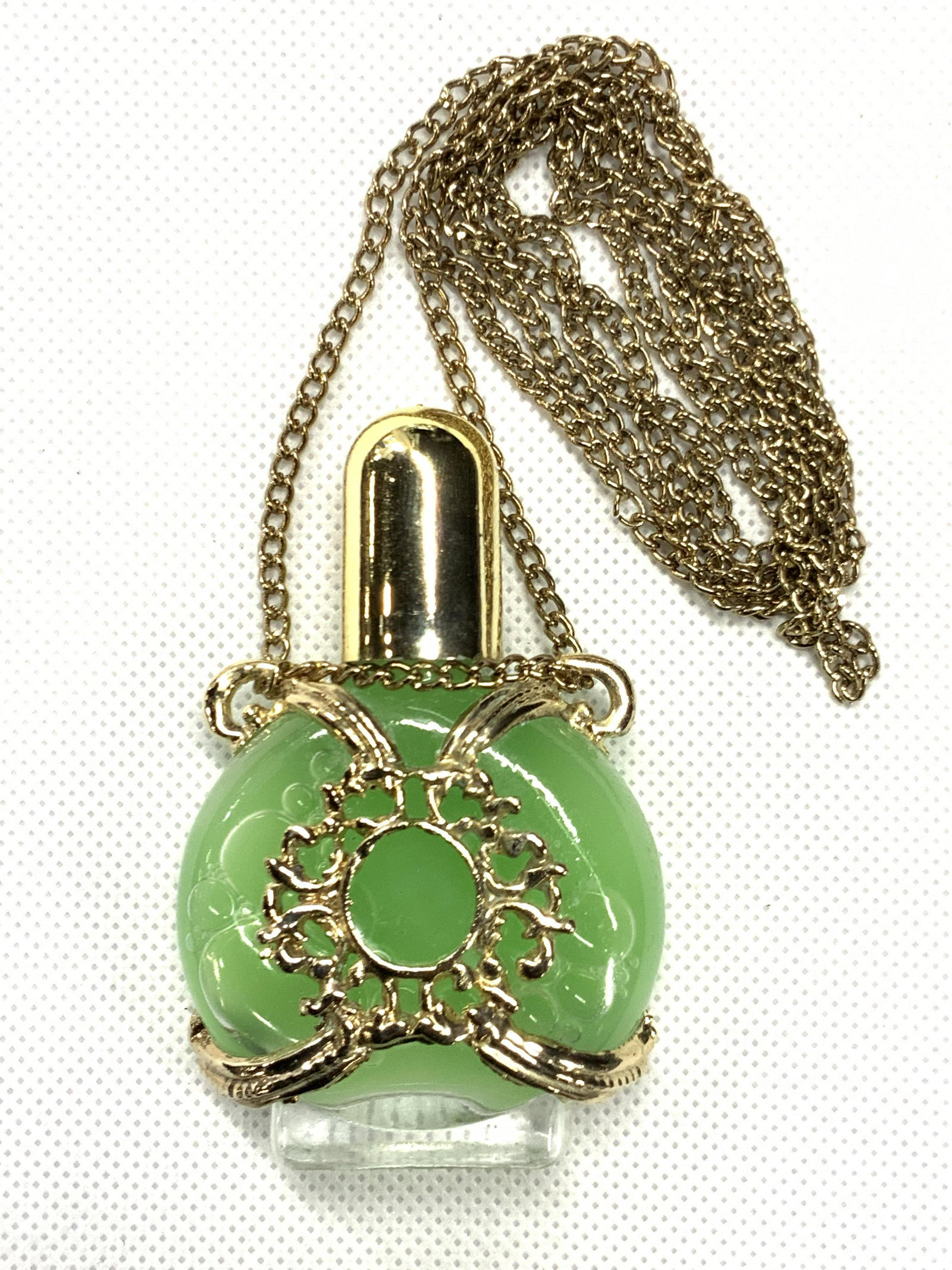Vintage Ornate Gold Toned Vial Necklace: Vintage ornate vial necklace with gold toned chain, the bottle is affixed to the chain using a gold toned harness made of metal with a sun form in the center. Bottle is filled with bubble blowing liqu