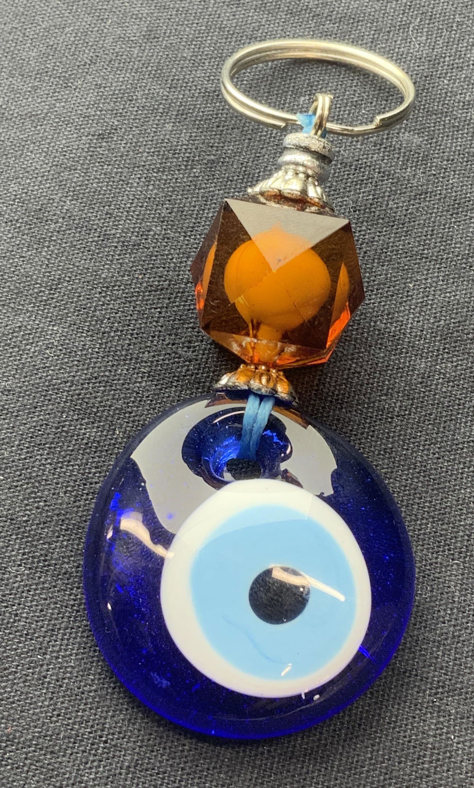 Evil Eye Keychain: Evil Eye Keychain, measures 3 1/2 inches tall. The evil eye is a look or stare that is believed to bring bad luck for the person at whom it is directed for reasons of envy or dislike. The perception o