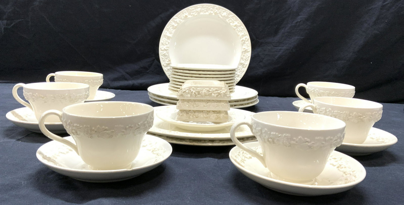 Set 30 WEDGWOOD Porcelain: Lot includes 4 dinner plates, 2 salad plates, 6 saucers, 6 teacups, 9 bread plates, & 3 chopstick rests/teabag rests. Each piece is cream toned and porcelain. Largest piece measures approx 10 inches w
