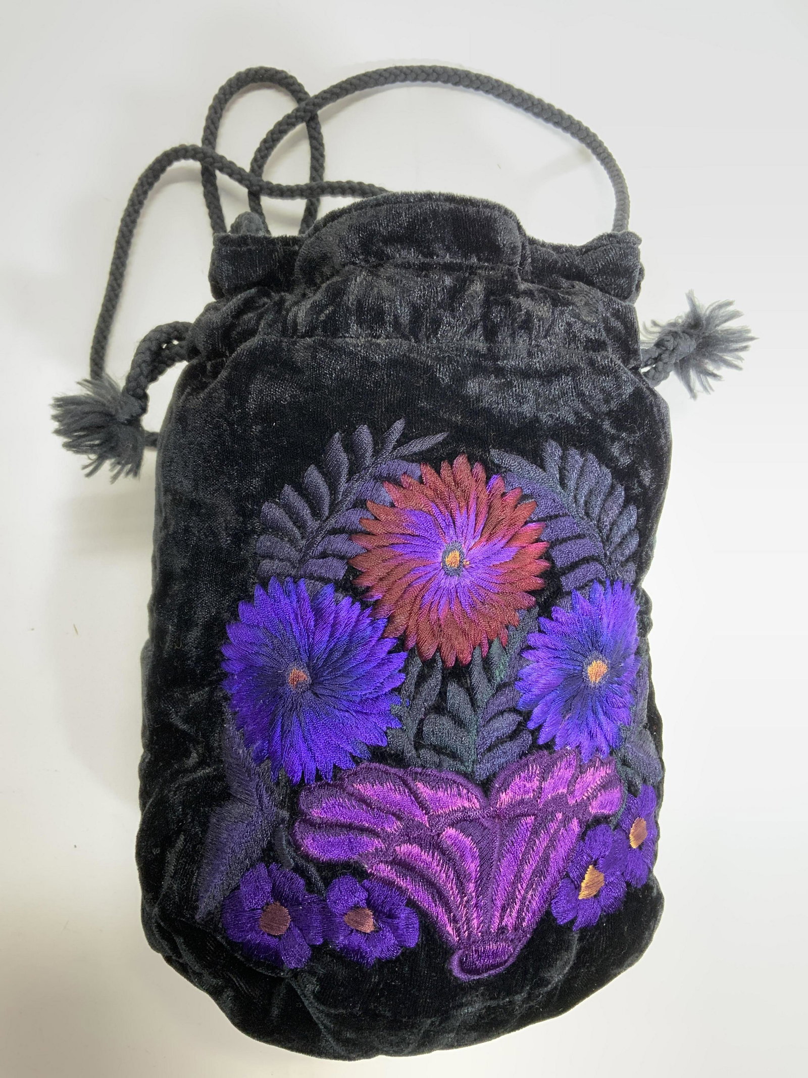 Floral Detailed Velour Pouch Bag W String Strap: Bag is black with floral detail including various purple tones. Pouch appears to possibly be velour. Piece has string style strap. Piece when hanging from strap measures approx 31 inches tall 6 inches