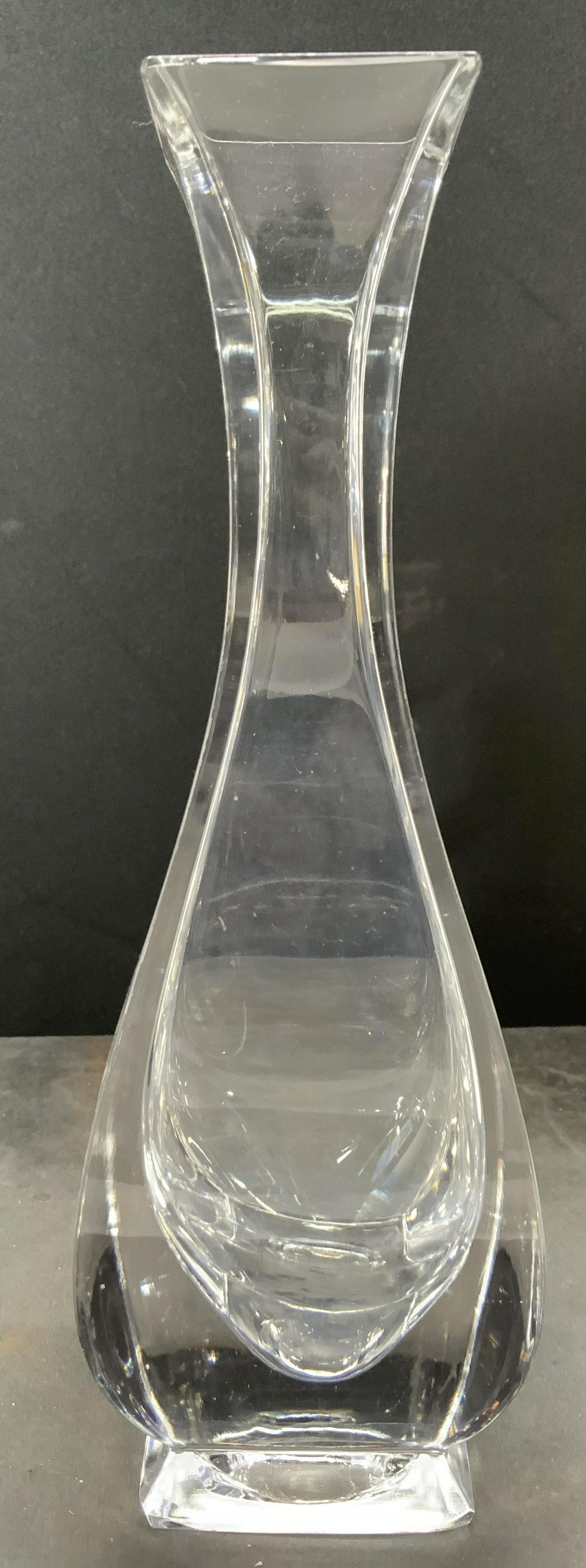 Footed Crystal Vase Vessel: Vase appears to be crystal, possibly glass. Vase is footed with square shaped rim & base. Piece has wide lower half which tapers inwards towards neck. 8 in heighy by 2.75 in wide and long. Vase, vesse