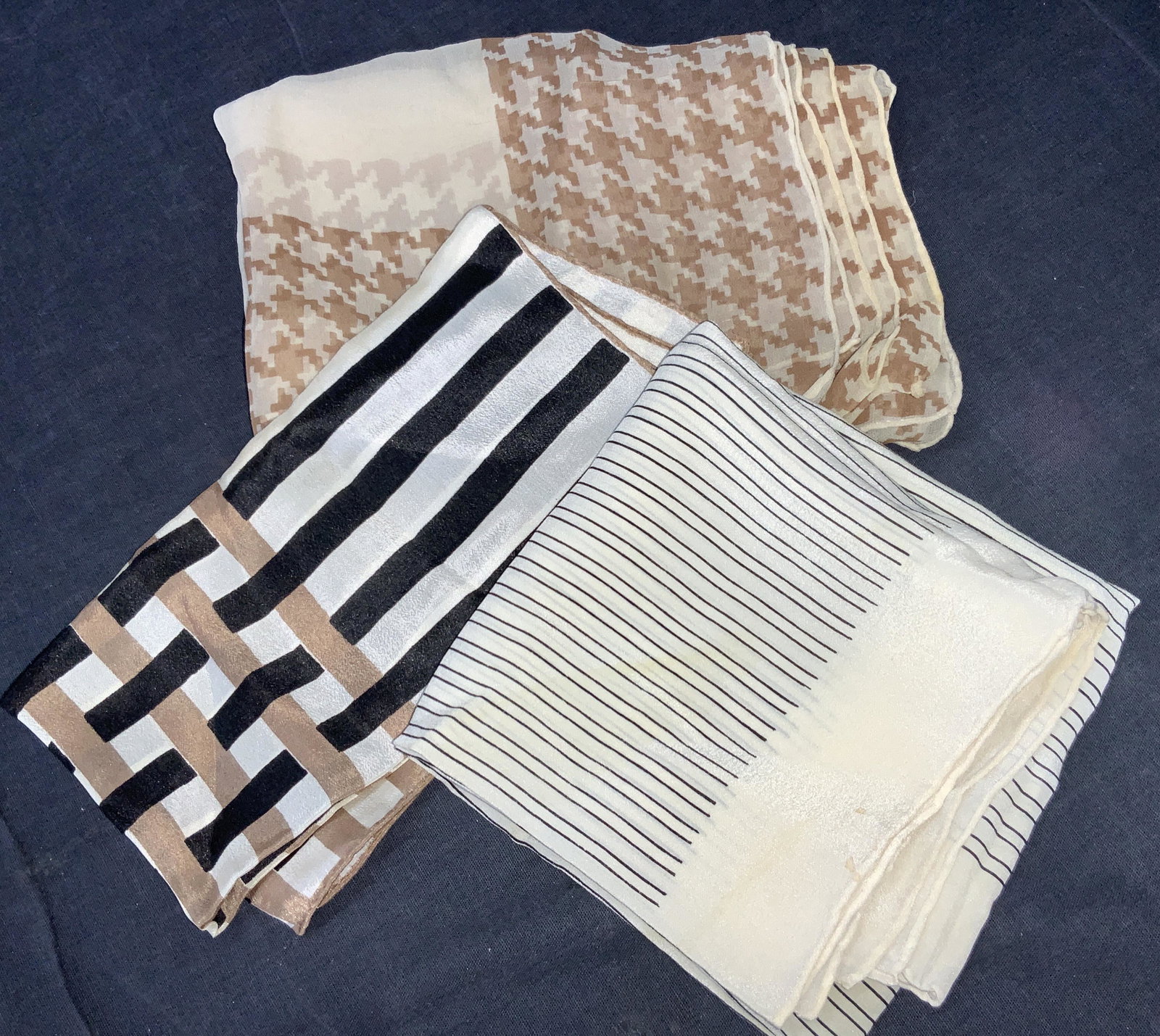 3 Silk Hand Rolled Handkerchiefs & Scarf: Group lot of 3 silk accessories. 1 cream toned with hand rolled edges, with black vertical lines throughout the center. 1 cream toned and brown hounds tooth patterned scarf with rolled edges. And 1 sc