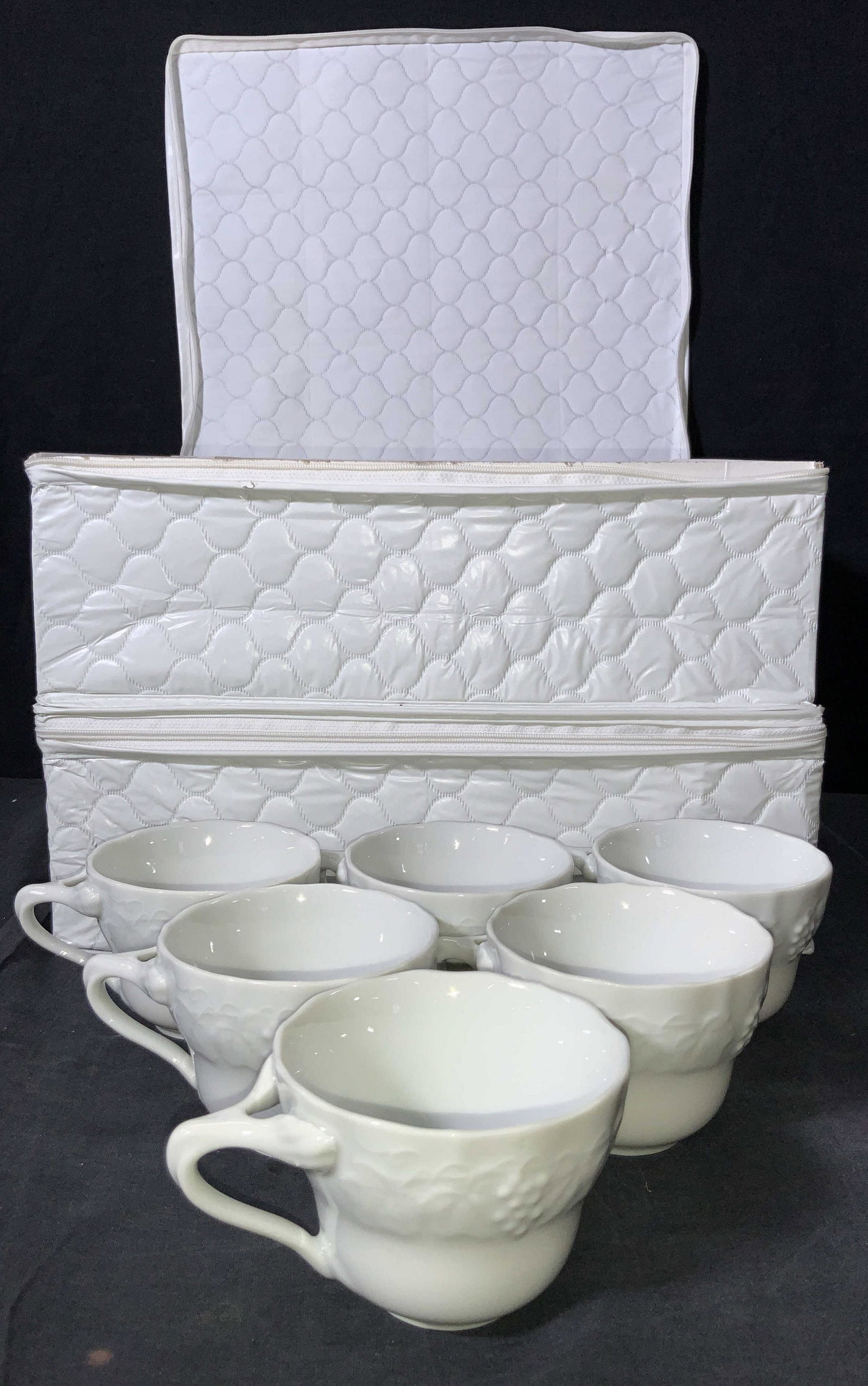 24 White Champagne Fine China Cups: 24 set of White fine China cups with raised motifs of fruit and leaves on exterior edge. All cups are marked White champagne fine china on undersides. Comes in storage boxes with separators for each c