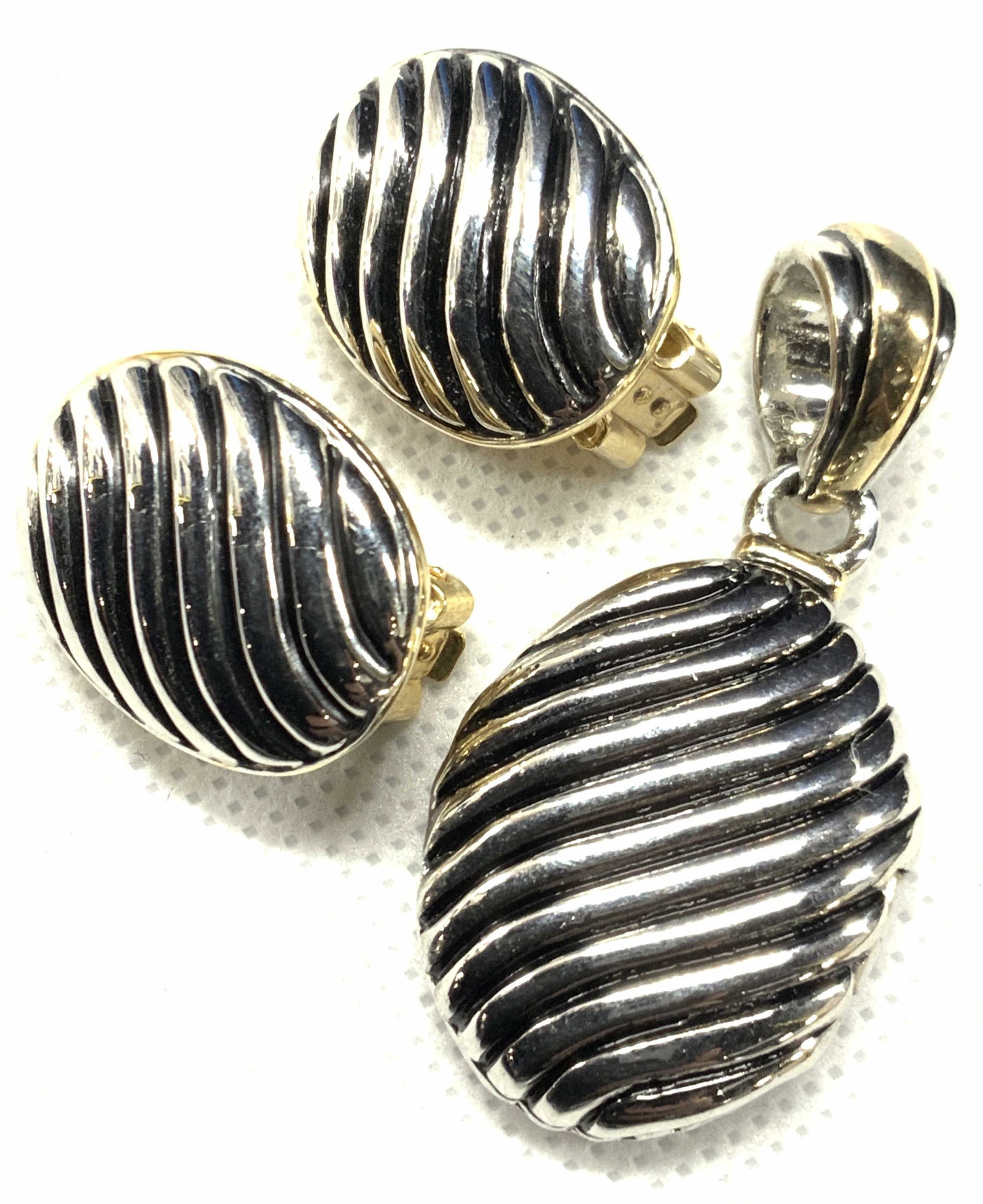 Vintage Matching Clip on Earrings & Locket Pendant: A vintage matching set of clip on earrings and necklace locket pendant, all a silver toned metal with waved grooves. Locket pendant opens to a mirror. Approximately 1.75 inches long. Vintage locket pe