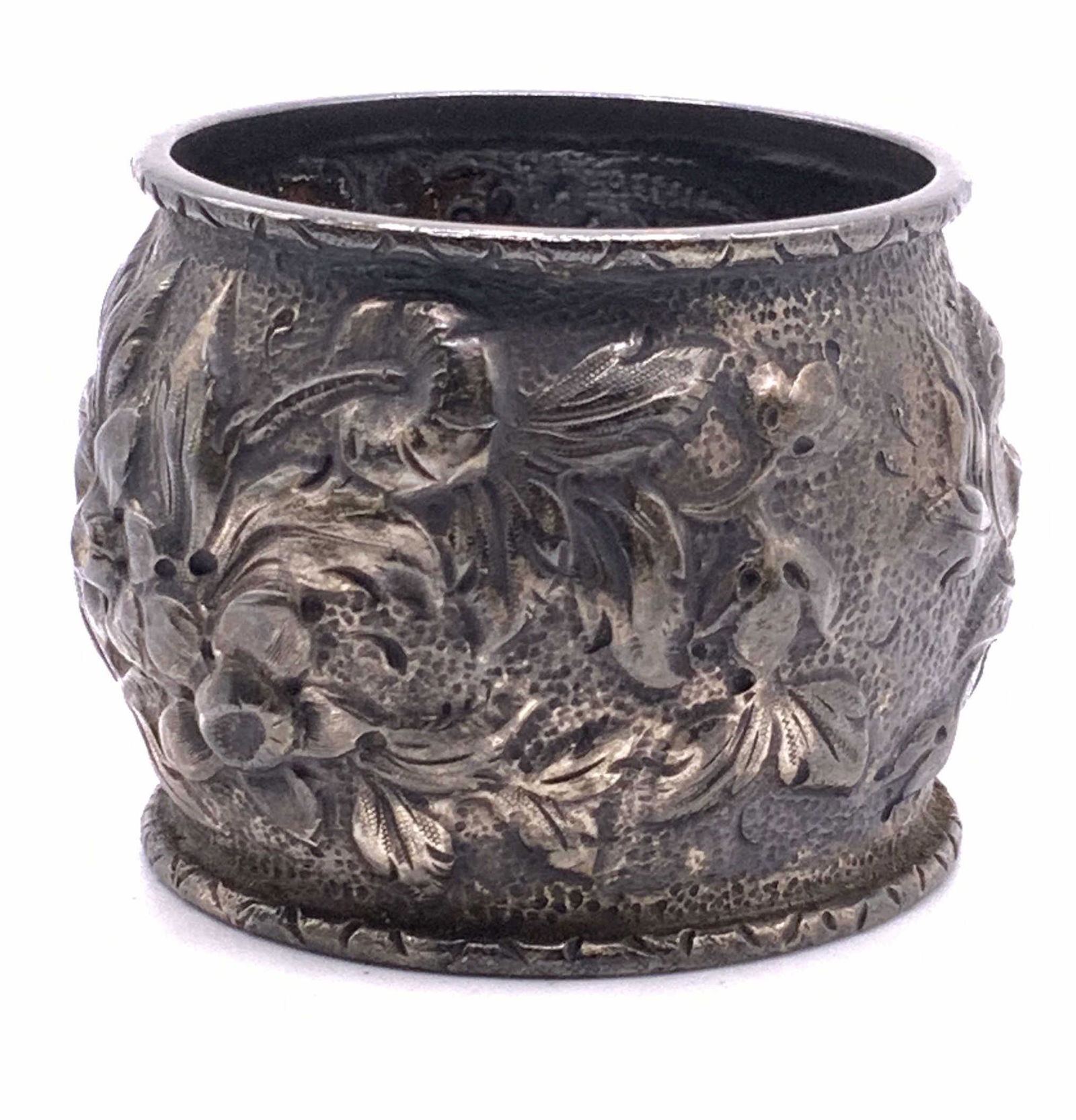 STERLING SILVER Vintage Floral Napkin Ring: A vintage STERLING SILVER floral napkin ring with embossed metalwork. Napkin ring measures approx. 1 6/8 inches diameter, 1 5/8 inches tall. Wear to finish consistent with use. Letters engraved on sid