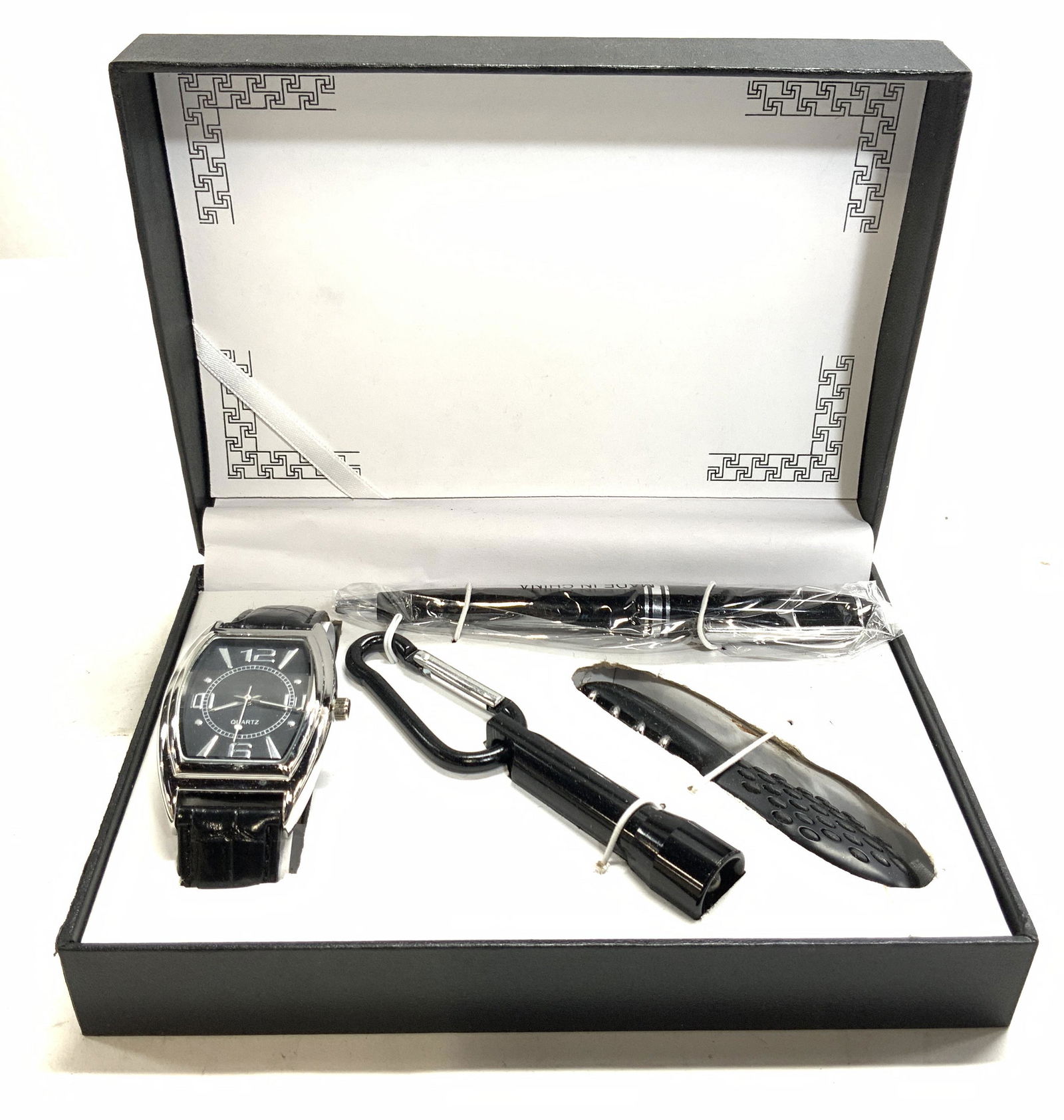 Pocket Accessories Gift Box, Watch, Pen & More: Gift box, black toned, opens to an assortment of gifts. 1 watch, with Quartz on the face. Stainless steel backing and black reptile patterned wrist band. 1 black pen, 1 keychain with flashlight and 1