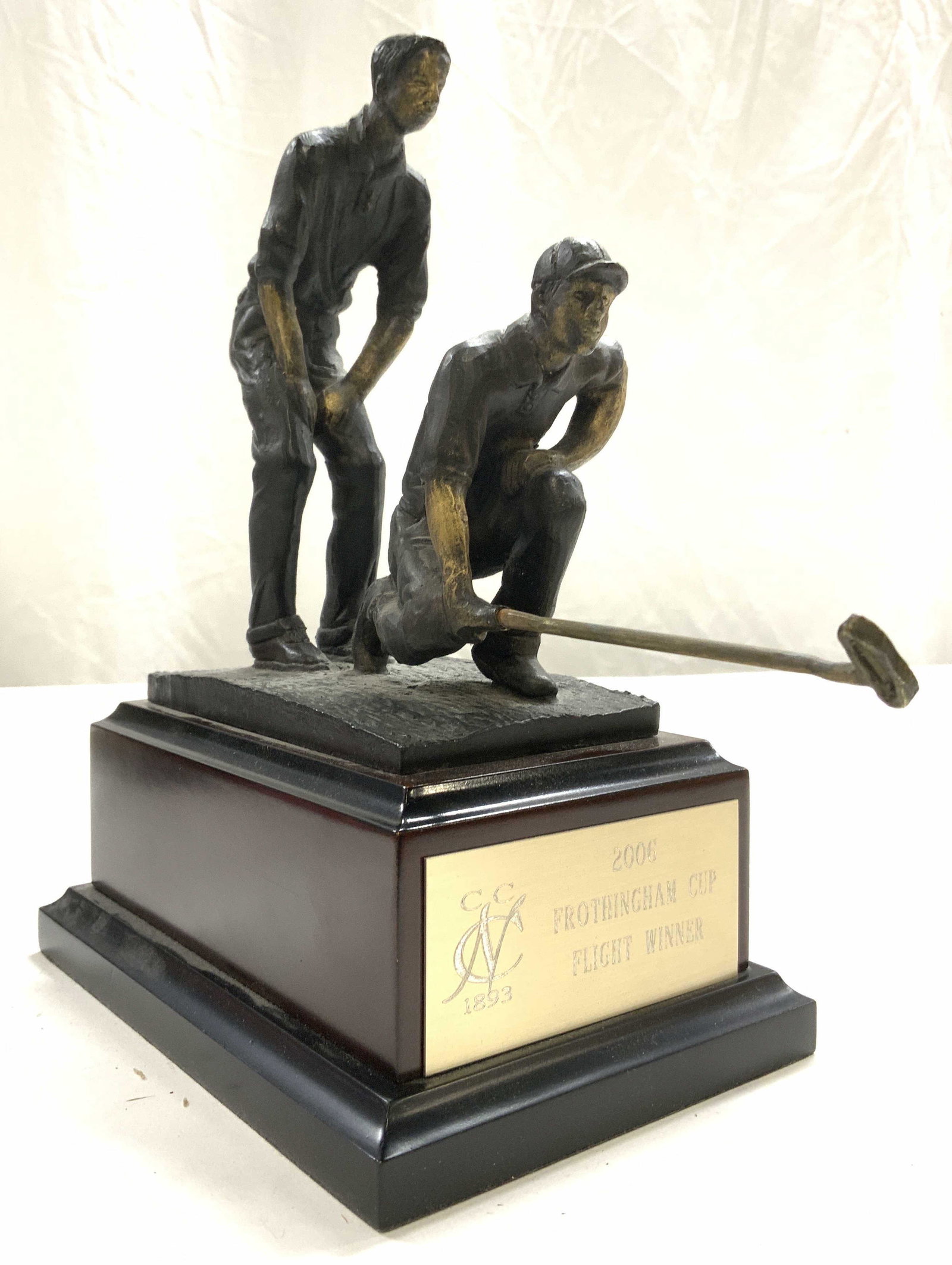 Monogrammed Wood & Metal Golf Trophy: Trophy is monogrammed 2006 FROTHINGHAM CUPFLIGHT WINNER. Piece depicts 2 male figures lining up a putt. Trophy is wooden and metal. Measures approx 9.5 inches tall 4.5 inches wide 9 inches deep. Troph