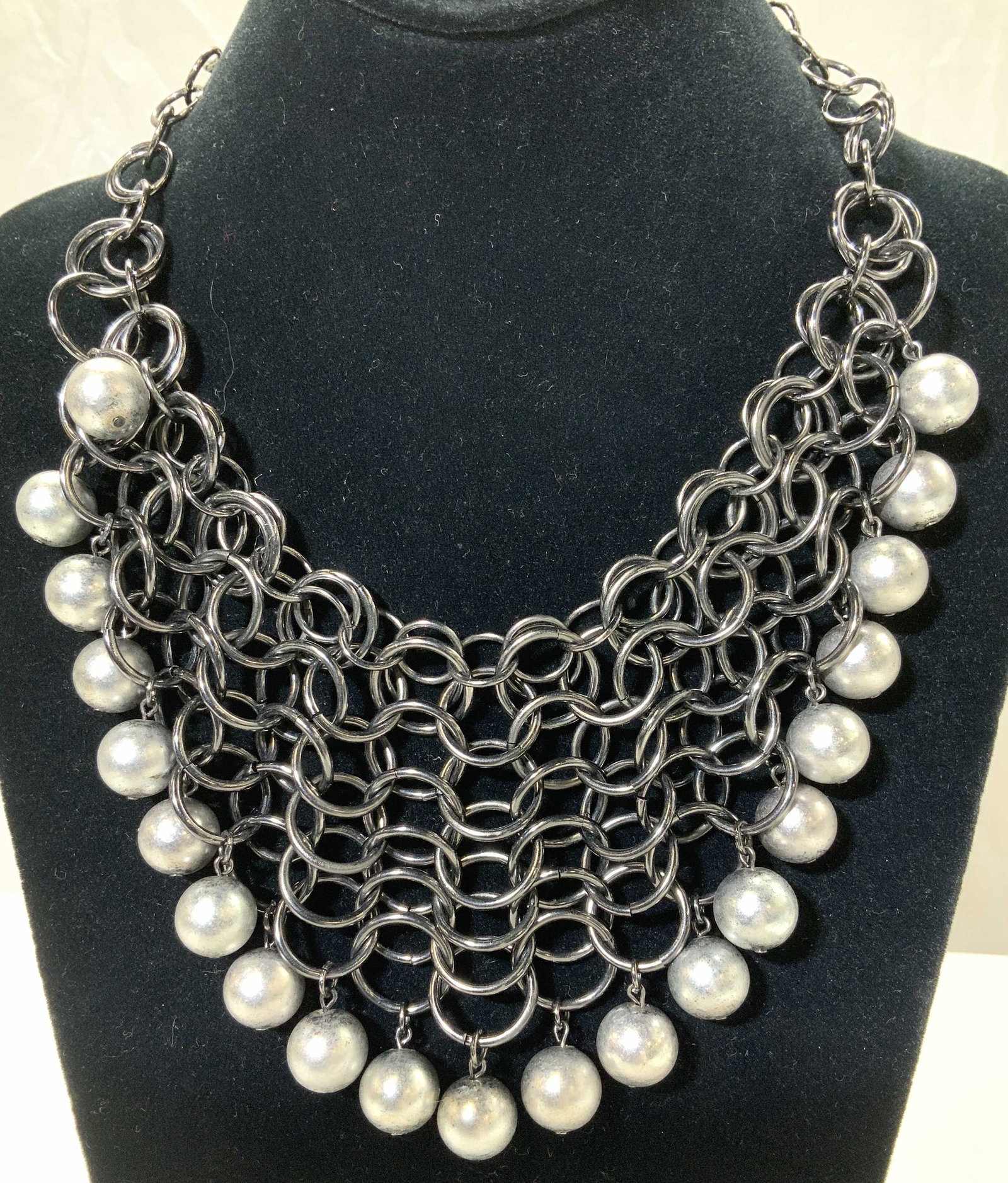 RJ GRAZIANO Sgn Gunmetal & Faux Pearl Bib Neck nwt: Round metal links in gunmetal with dangle silver costume pearls along edge. Bib designer shapes in a wide V pattern and measures 6.5 x 3.5 in. Adjustable length , 15 in. Longest, signed charm, new wit