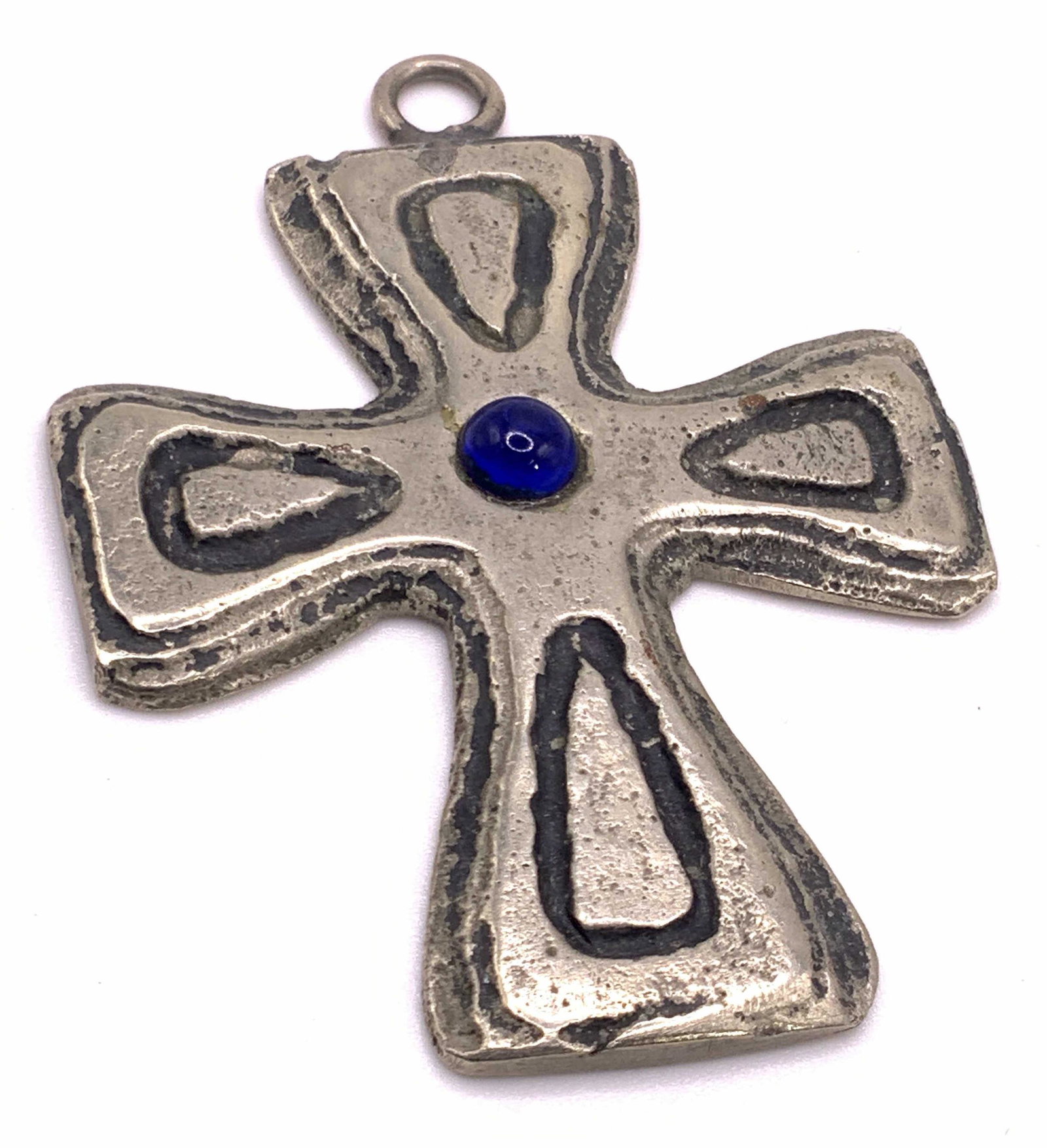 Cross Form Blue Costume Cabochon Pendant, Vintage: A silver tone etched metal cross form pendant with a blue costume cabochon to the center. Measures approx 2.5L x 2W in. Measurement includes bail. Surface wear consistent with use and age. Property of