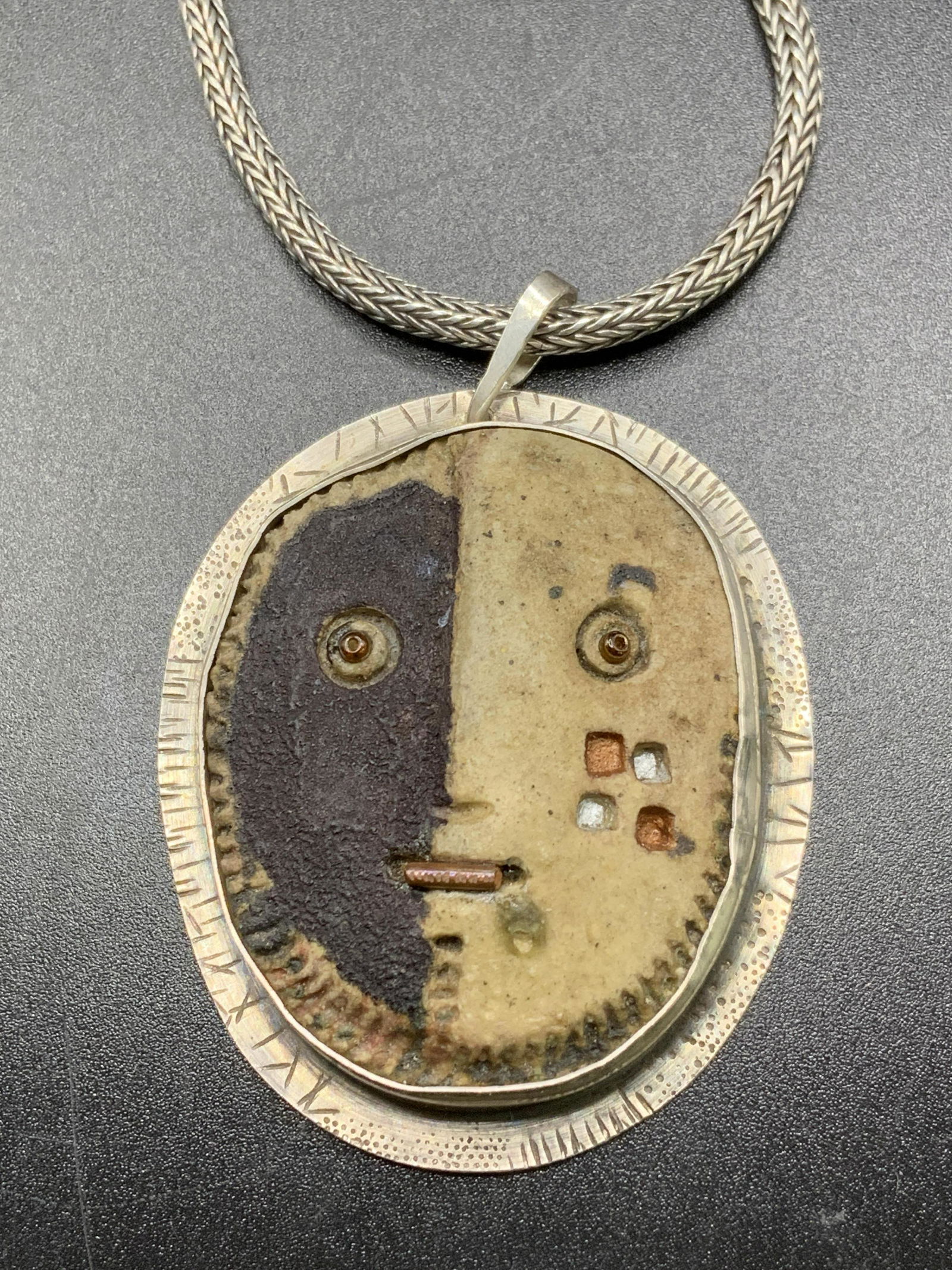 LETERNEAU Sterling Silver Carved Mask Pendant: JAMES LETERNEAU hand carved, possibly bone, mask style pendant bezel set in STERLING SILVER. Snake chain with S hook closure. Signed LETERNEAU, STERLING on back of pendant. Necklace measures approx. 2