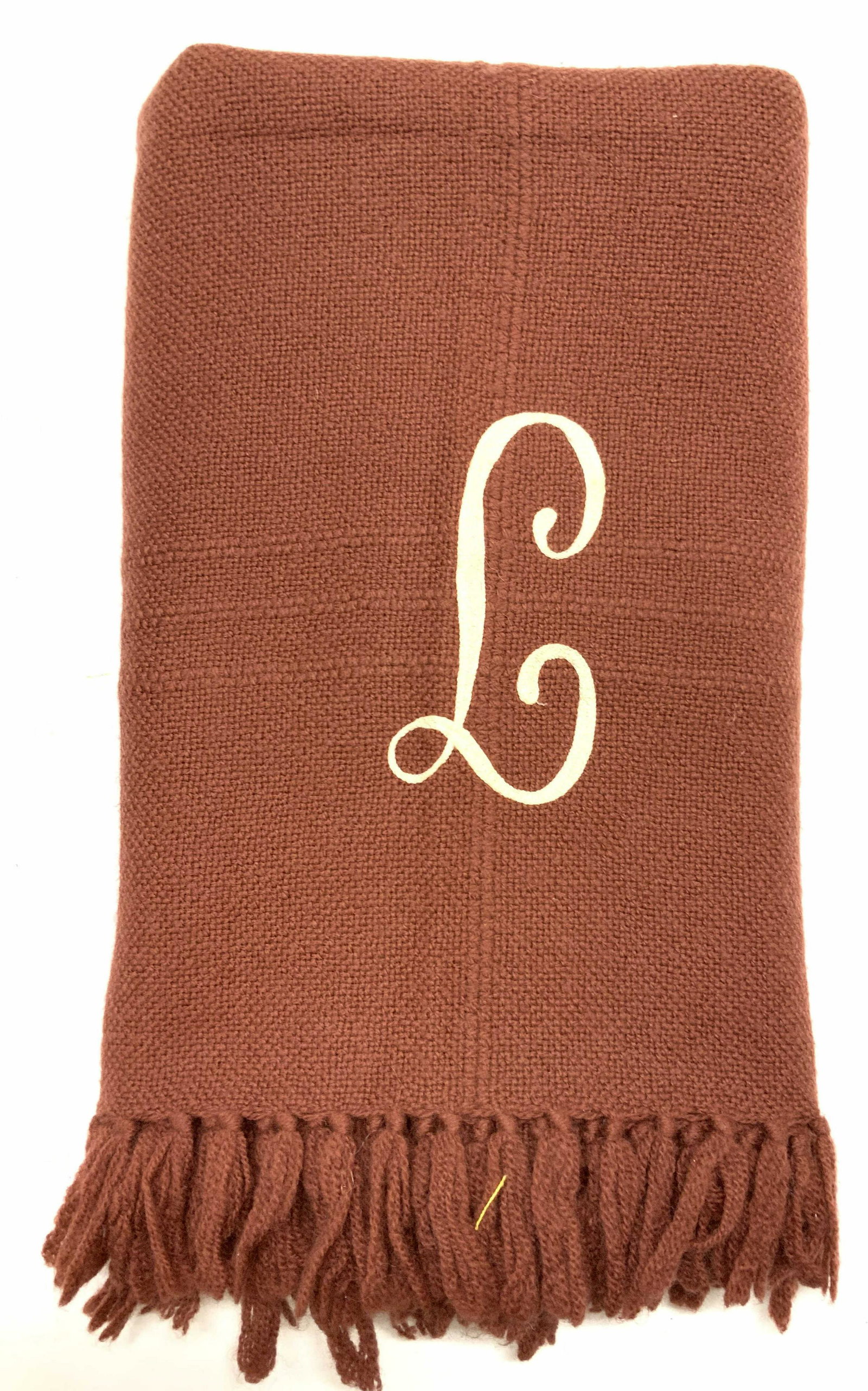THE THREE WEAVERS Embroidered Cotton Blanket: Maroon toned cotton woven blanket, embroidered with an off white threading L initial. Marked on tag, The Three Weavers, Houston Texas, Hand woven 100% Virgin Wool. Approximately 76 inches x 52 inches.