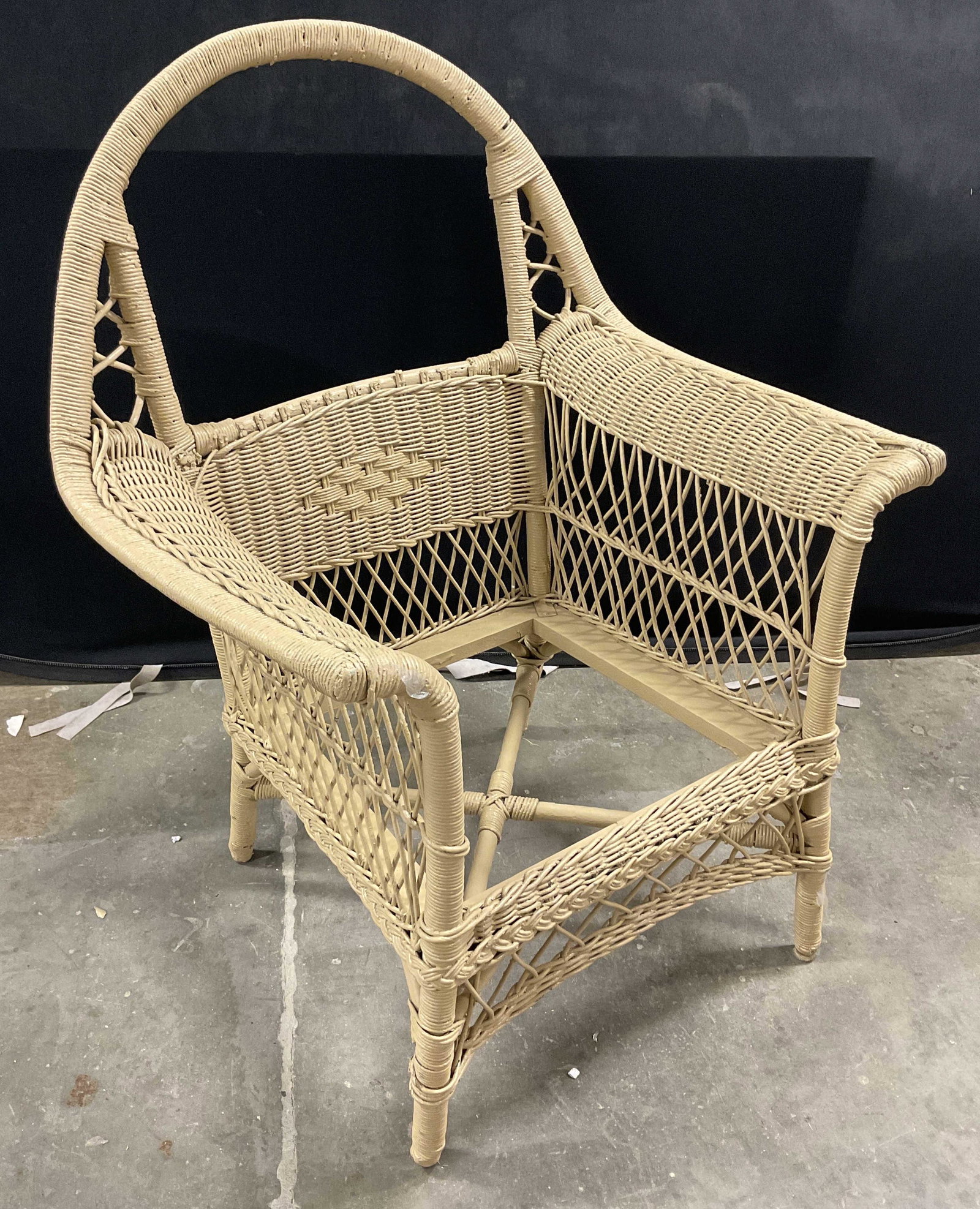 Sand Toned Wicker Chair: Wicker chair painted in a sand toned color. Arched backrest has opening to it and below an intricate weaved pattern. No cushion with piece. Property of Martha Stewarts East Hampton Long Island, NY Est