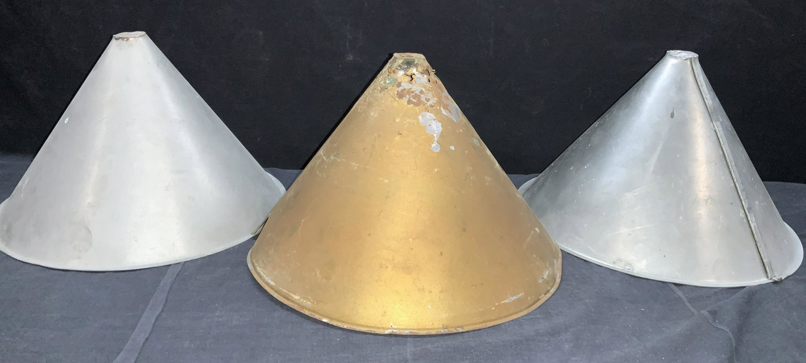 3 Vintage Tin Cone Covers: 3 Tim covers in cone shapes. 2 white metal and 1 gold toned painted cover. Approximately 8.75 inches tall. Minor wearing to exteriors, and rusting to 1 cone. Property of Martha Stewart Katonah, N.Y. E