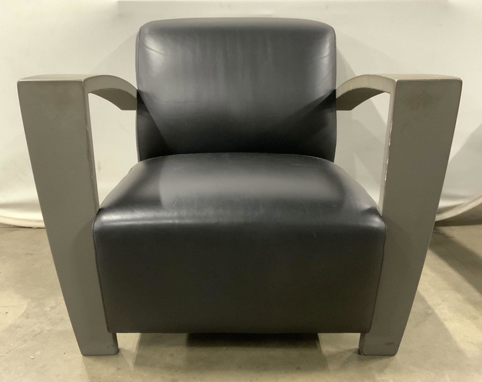 Industrial Modern Leather Armchair: Chair has S trademark on lower left side. Armchair appears to possibly be leather. Arms appear to be wood with slate toned finish. Armchair, lounge chair, living room furniture, lounge furniture, home