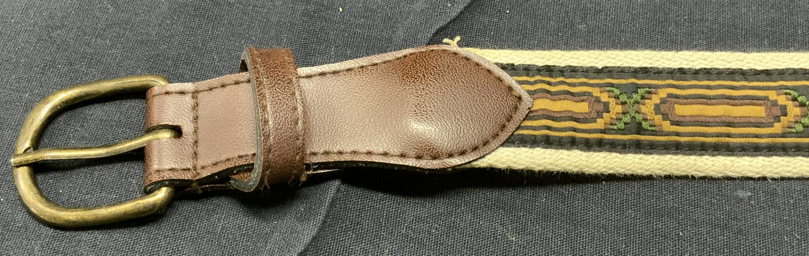 Leather & Woven Material Soft Hand Belt: Leather & Woven Material Soft Hand Belt, sticker on belt reads 30, white with green and brown geometric pattern, bronze toned hardware, brown leather piece attached at buckle & holes. Measures approx 