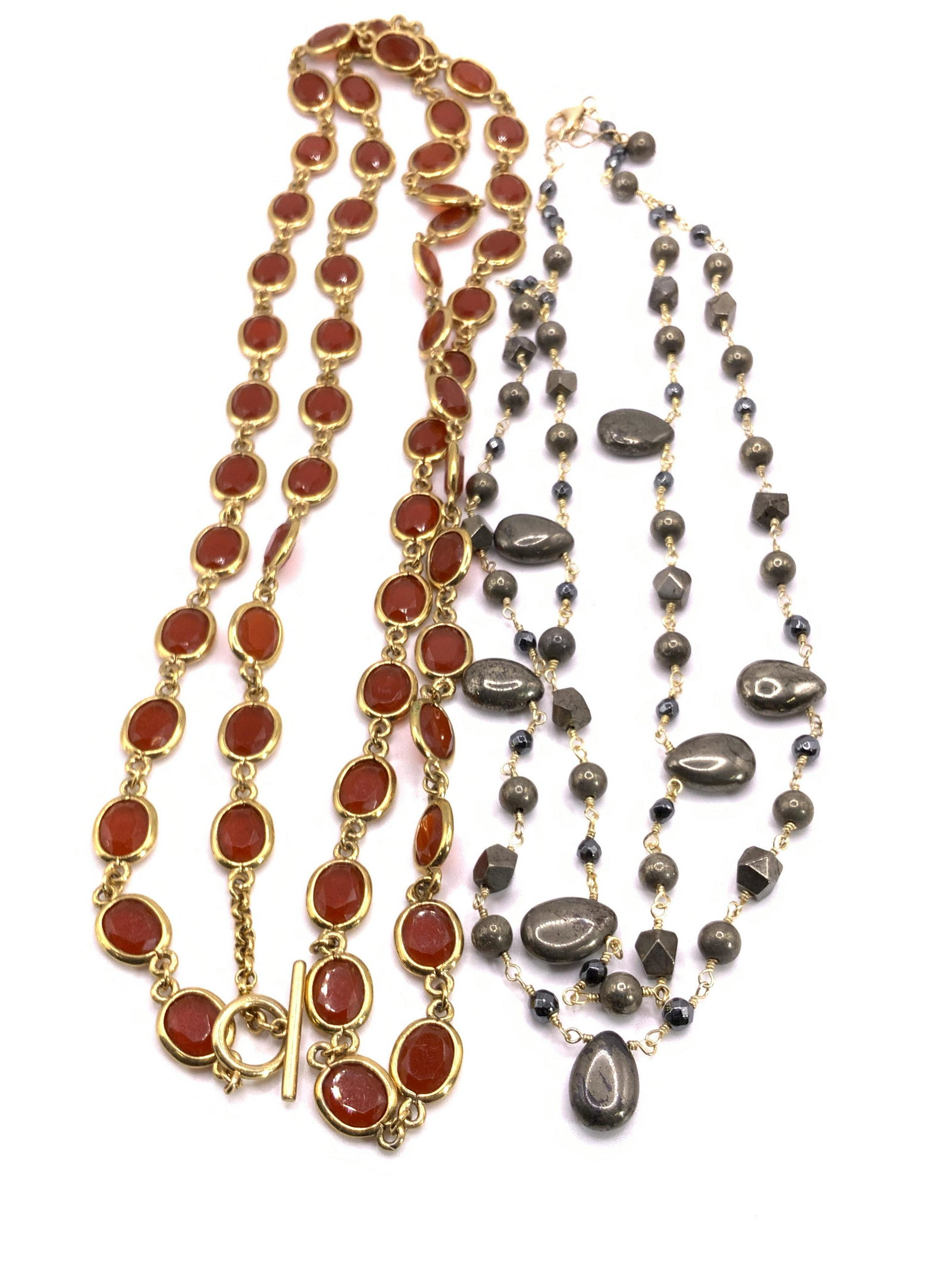 Lot 2 Vintage Costume Stone Necklaces, Jewelry: Two vintage gold tone metal chain necklaces. One piece features carnelian hued faceted bezel set crystals. Toggle clasp closure. Length approx 42 inches. The other necklace features two chains adorned