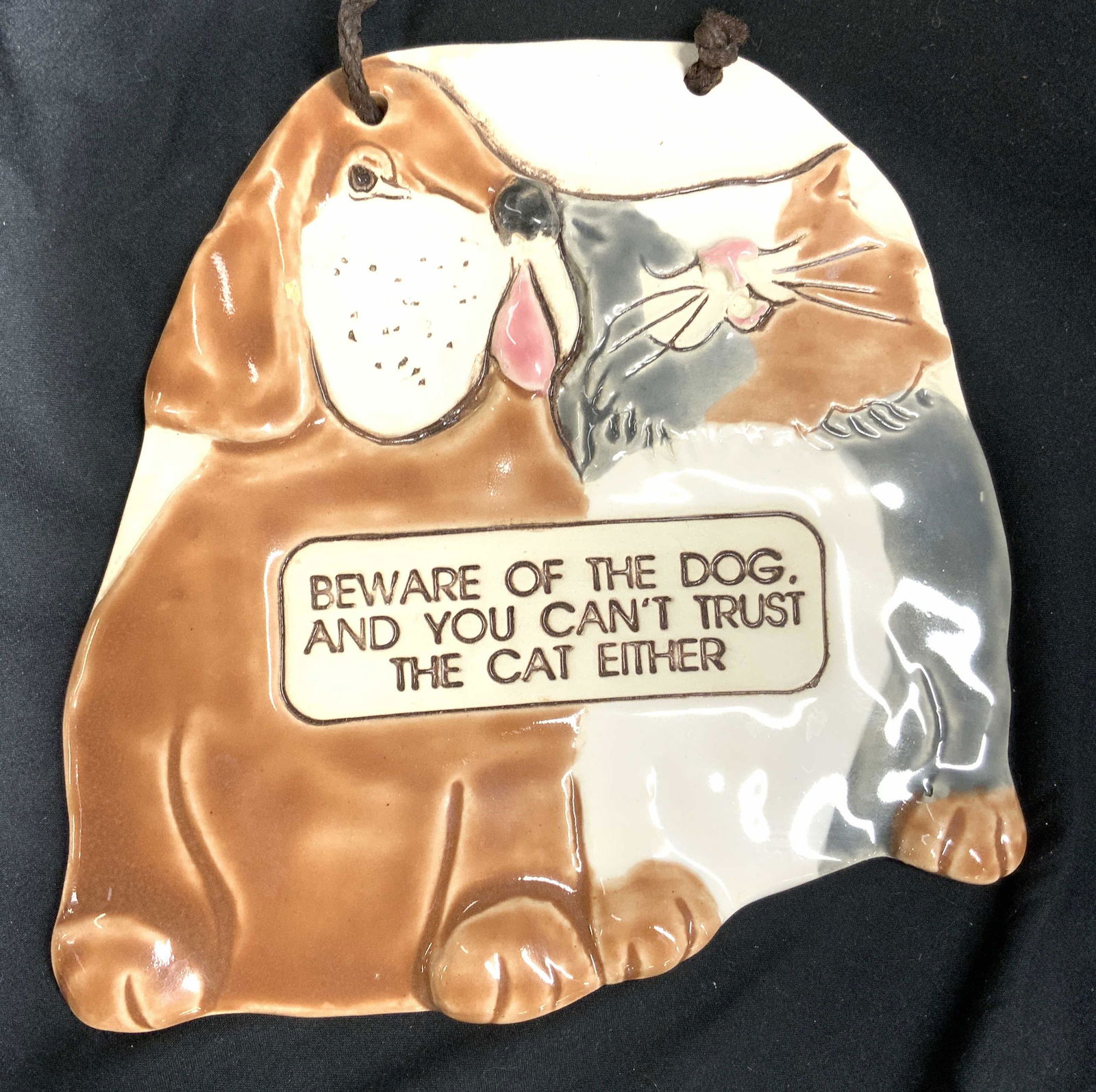 SMOKY MOUNTAIN POTTERY Ceramic Wall Hanging: Backside has tag which reads SMOKEY MOUNTAIN POTTERY. Wall hanging is ceramic and depicts a seated cat and dog figure. Piece reads Beware of the dog and you cant trust the cat either. Piece measures a