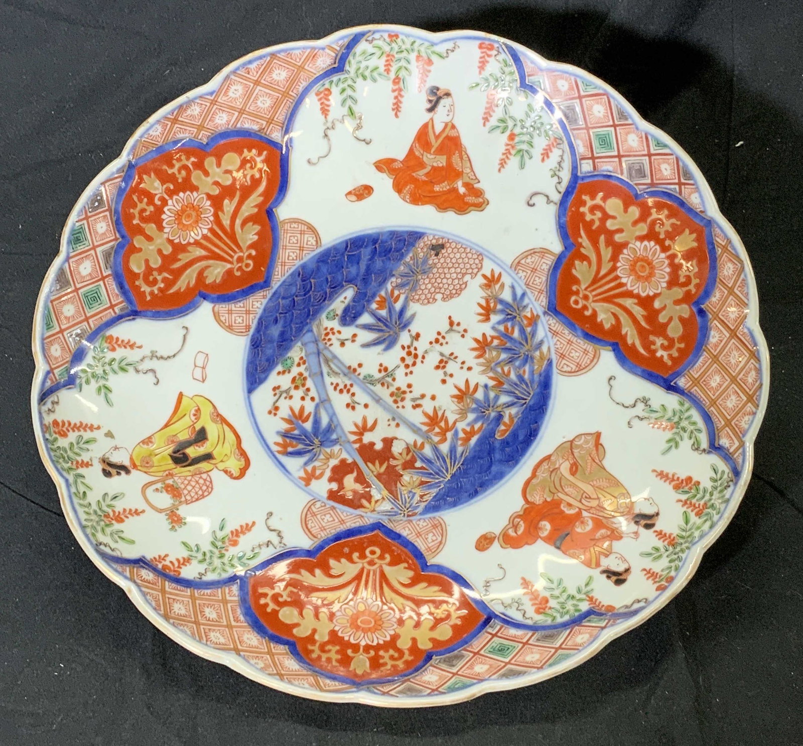 Vintage Hand Painted Porcelain Asian Centerpiece: Vintage hand painted porcelain Asian centerpiece bowl. Japanese Imari style, brightly colored red and blue with yellow, green, and gold accents. Geisha figures with ornate cartouche and nature motif. 