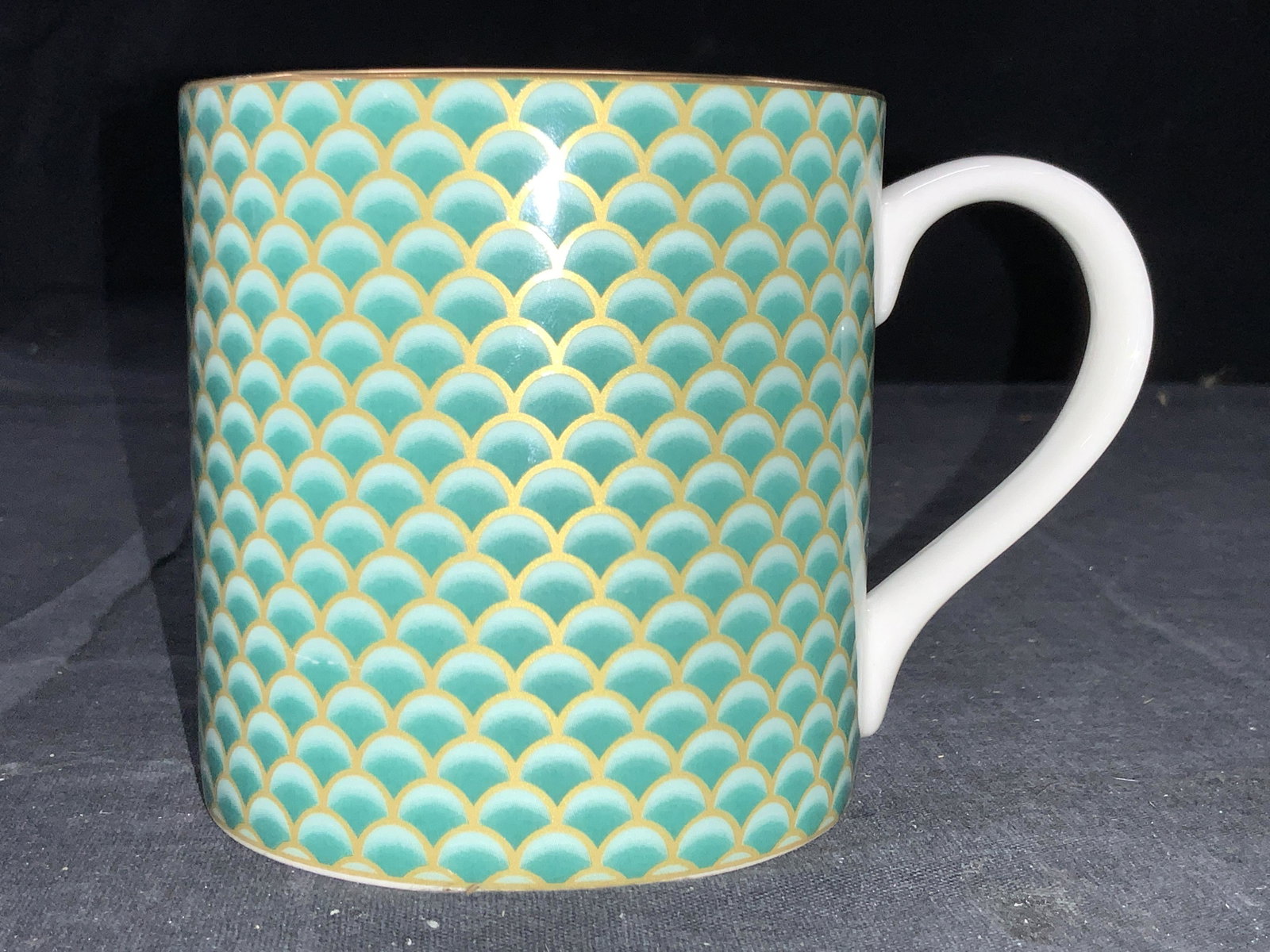 FORTNUM & MASON Fine Bone China Mug: Fine bone fine mug with a fish scale pattern on exterior. Gold gilt rim and gold toned streak on handle. Marked Fortnum & Mason est 1707, Fine bone China, made in England. Approximately 3.5 inches tal
