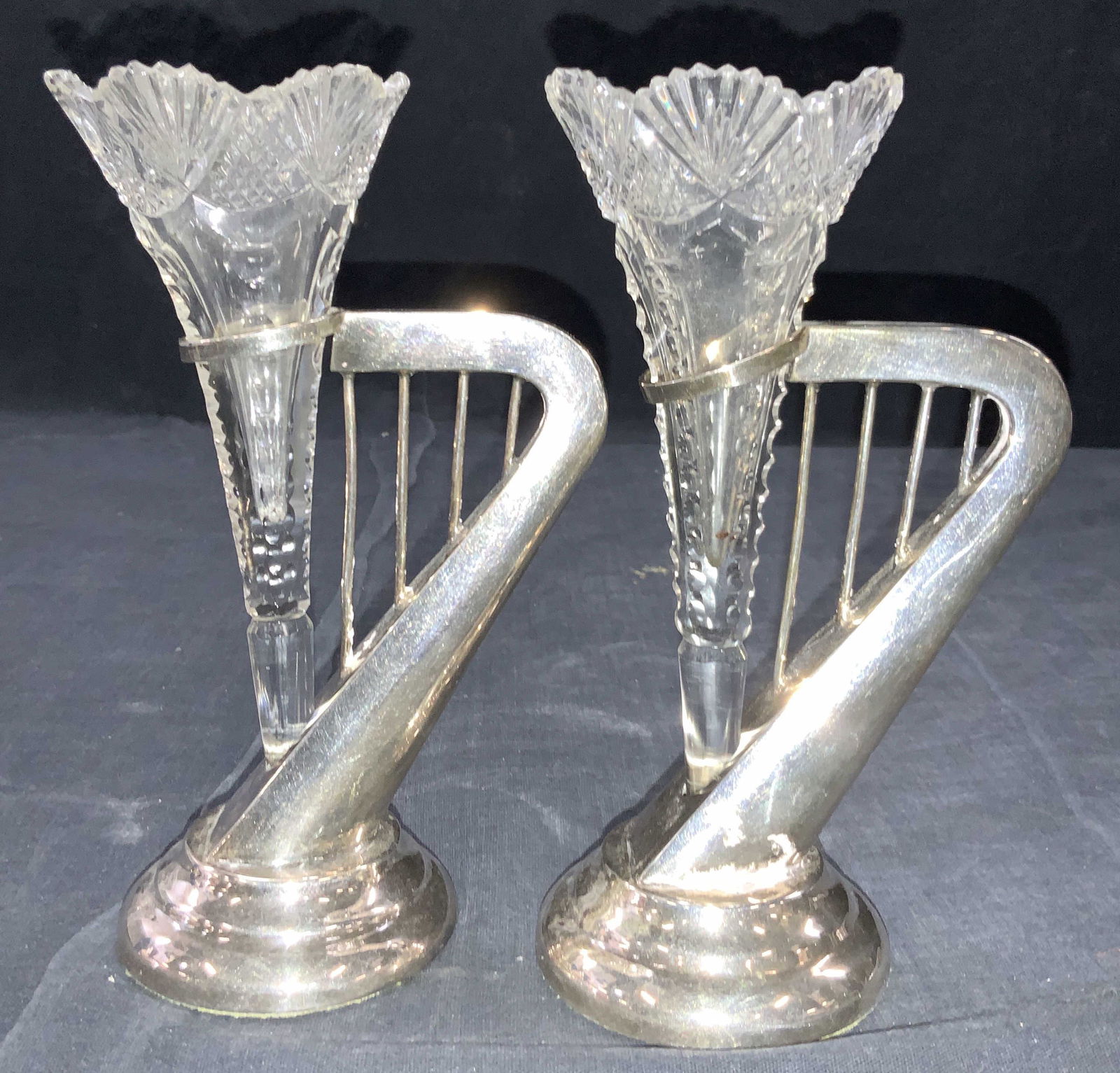 Vintage Sterling Silver & Cut Glass Vessels: Pair of cut glass vessels within harp shaped sterling silver holders. Vessels are pointed at the ends, with ribbed grooves going up and scalloped rims. Holders are shaped to resemble harps. Tested pos