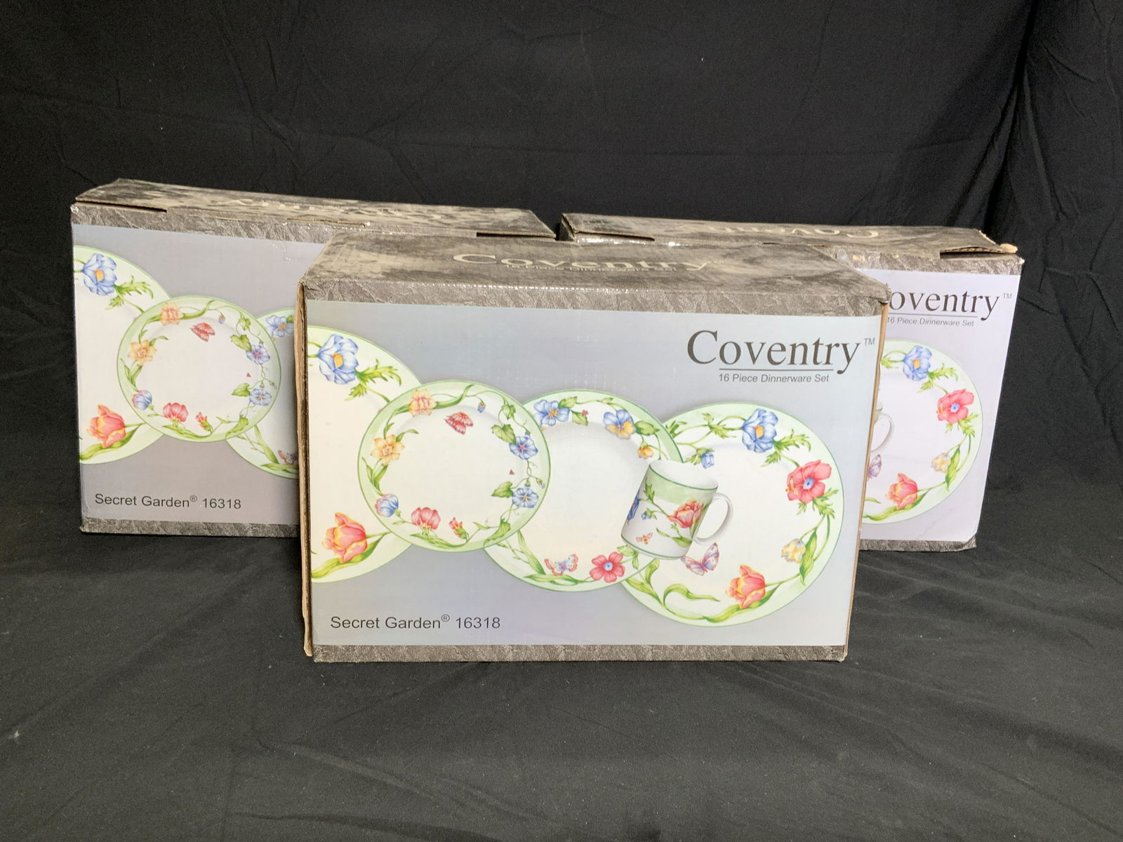 COVENTRY Secret Garden Porcelain Dinnerware Sets: Lot of 3 Coventry Secret Garden dinnerware sets in original boxes. Floral and butterfly motif on fine porcelain. Each set contains 16 pieces total - 4 dinner plates, 4 salad plates, 4 soup bowls, and