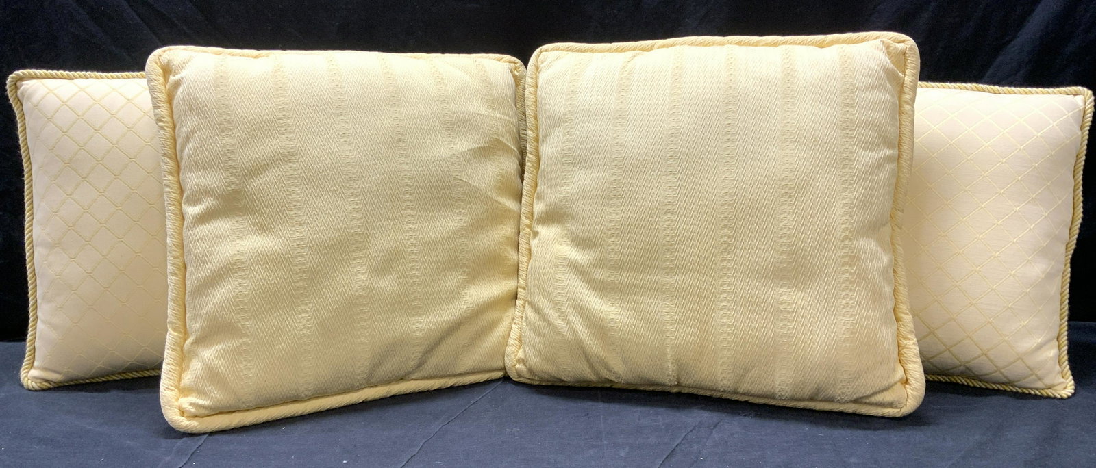 Lot 4 Yellow Gold Toned Pillows: Lot includes 2 large pillows & 2 smaller pillows. Each pillow has square shape. Smaller pillows have braided welting and diamond shape embroidery detail. Larger pillows have zig zag detail. Larger pil