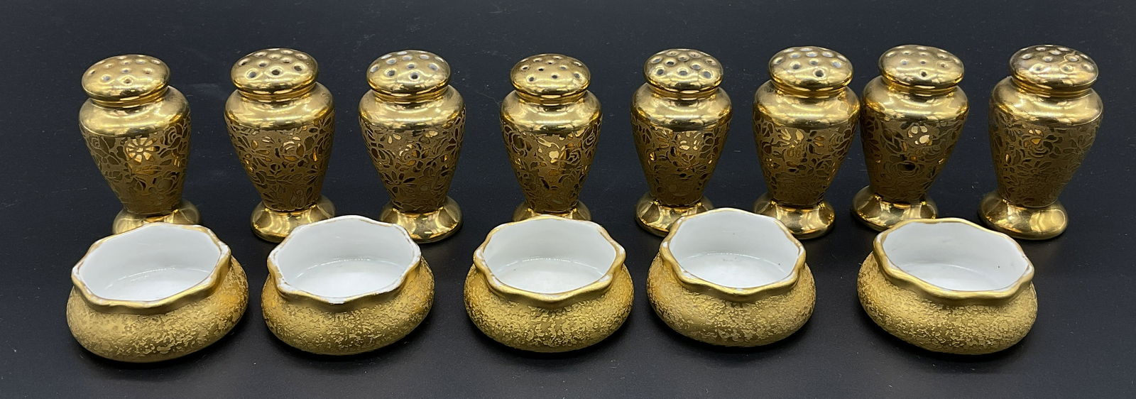 Set 13 Salt Pepper Shakers w Salt Cellars, Germany: Pickard style. Set 13 Fine China Salt Pepper Shakers w Salt Cellars. Marked on undersides Made in Germany. Possibly gold finish. Stamped P 5559 Germany. 5 salt Cellars, 8 shakers. Shakers have a flora