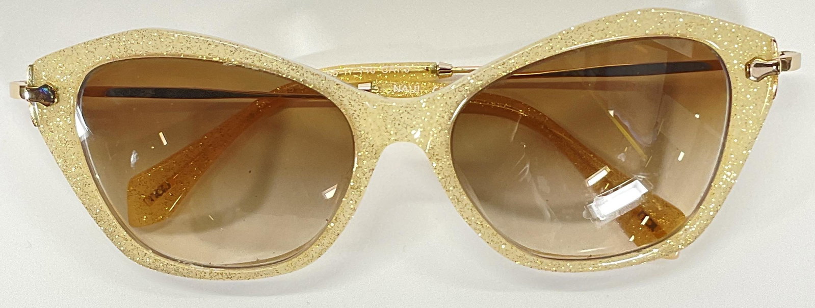 NAU Sparkly Sunglasses: NAU Sunglasses, in a light yellow town with gold toned sparkle's. Lens measures approx 2 inches, ear piece measures approx 5.5 inches. Wear to piece consistent with age and use. Lenses can be replaced