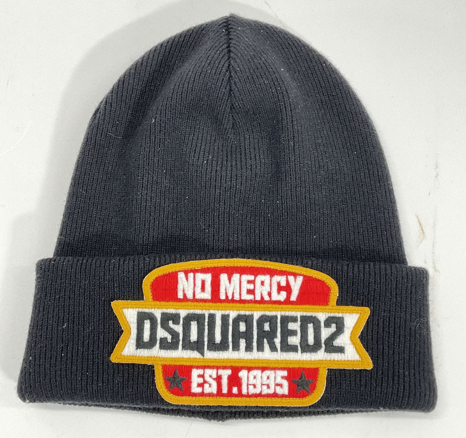 DSQUARED2 Knit Hat: DSQUARED2 Knit Hat. Black knit hat, with patch on front, No Mercy DSQUARED2 Est 1995. Inside tag reads made in Italy. Possibly never worn. Measures from top to bottom approx 9.5 x 9 inches. DSQUARED2