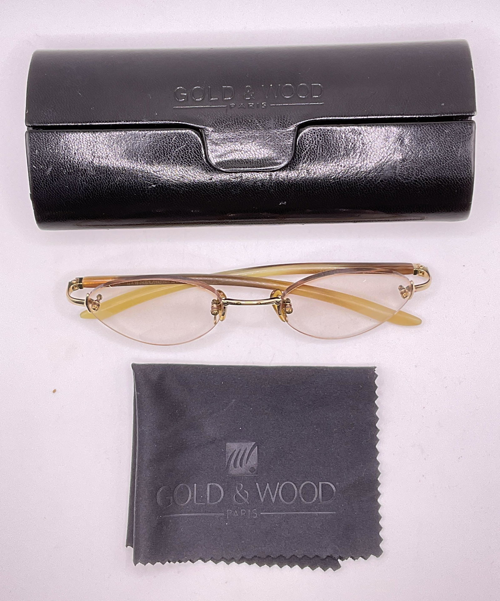 GOLD & WOOD Glasses & Case, Paris: GOLD & WOOD glasses. Glasses are possibly made of genuine horn. Inscription on side of glasses illegible. Multi-toned rims. Lens measures approx 1.75inches. Ear piece approx 5.5 inches. Some significa