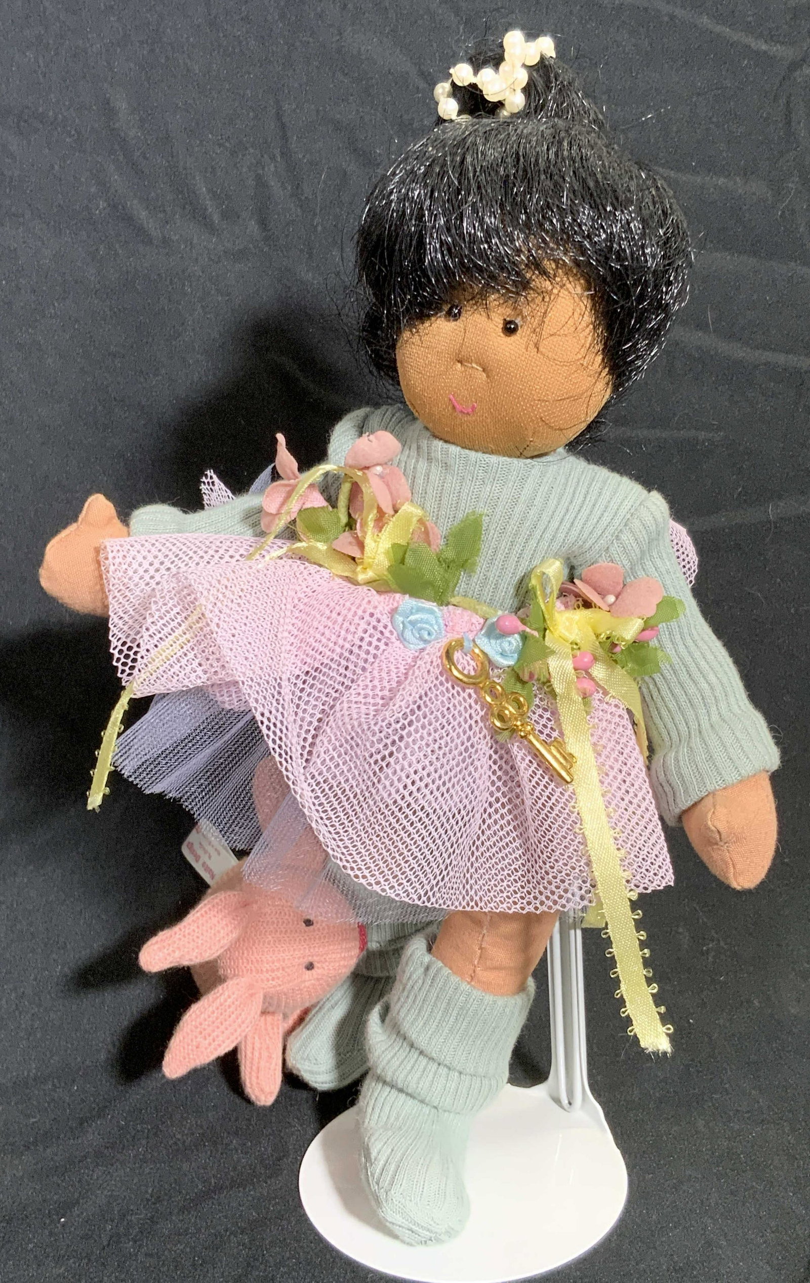 NAITO DESIGN Girl W/ Rabbit Fabric Doll, Stand: Crafted from fabric materials the display doll features a girl with a rabbit attached to her leg. Tags to rabbit and girl read NAITO DESIGN. Measures approx 10H x 6W in. Measured at widest point. Meas