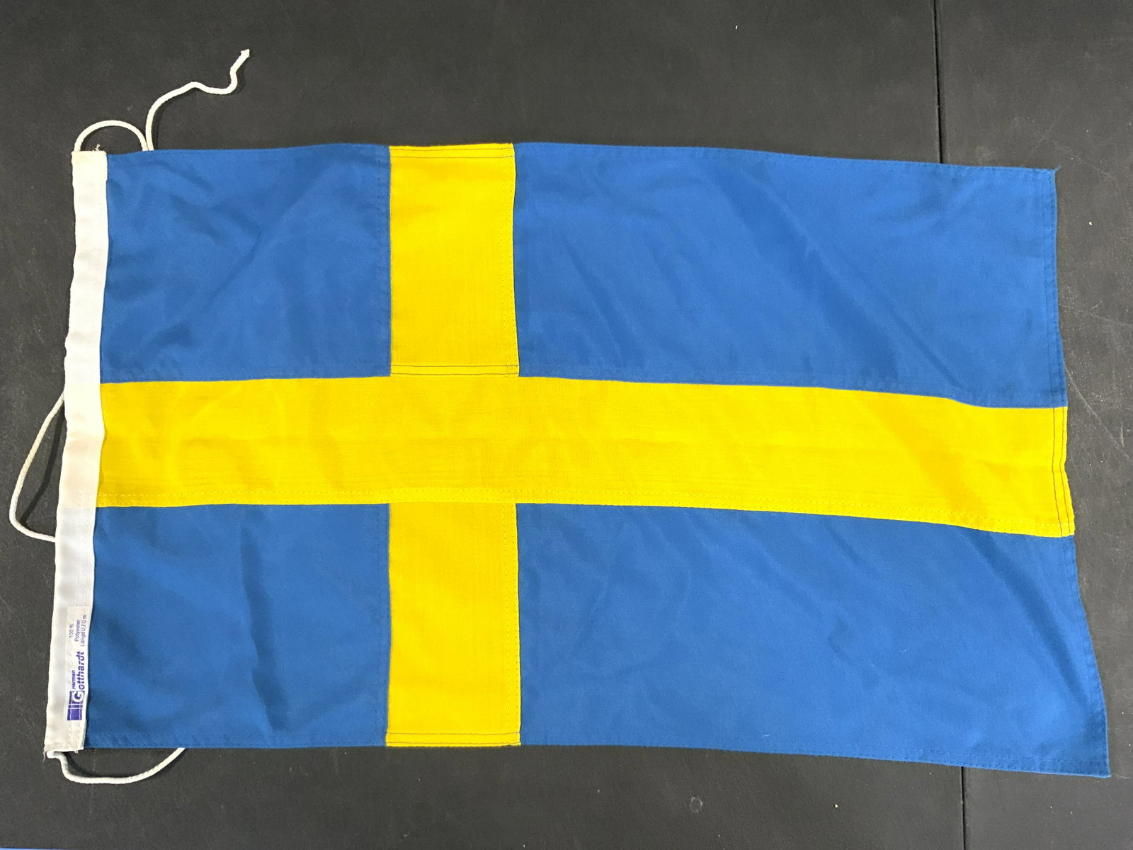 Lot 3 Swedish Flags: Lot includes 3 flags, each Swedish. Includes brands such as FLAGGFABRIKEN TELLUS, NYA STOCKHOLMS FLAGGFABRIK & HERMAN GOTTHARDT. Measures approx 58 inches long 36 inches tall. Flags, Swedish flags, fa