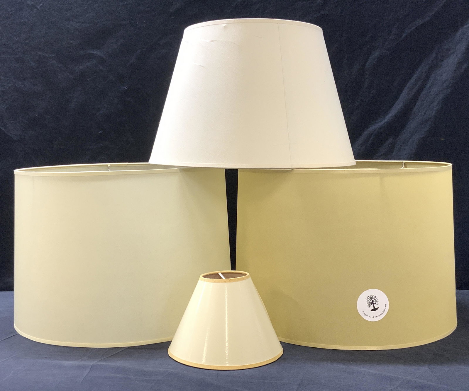 Lot of 4 Minimalist Beige Lampshades: Lot of 4 Minimalist Beige Lampshades, includes 2 drum lampshades and 2 empire lampshades. Each drum is composed of a hard possible styrene material and measure approx 11 x 15 in. One small empire shad