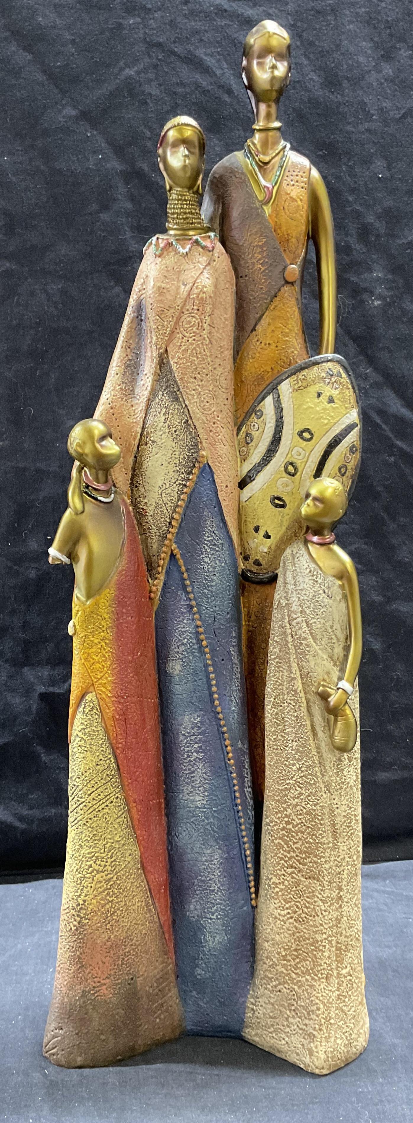 Maasai Inspired Resin Sculpture: Maasai Inspired Resin Sculpture, no apparent inscriptions or markings, a family of four in African style clothing, measures 22 3/4 inches tall x 6 7/8 inches at widest point, surface wear to piece, on