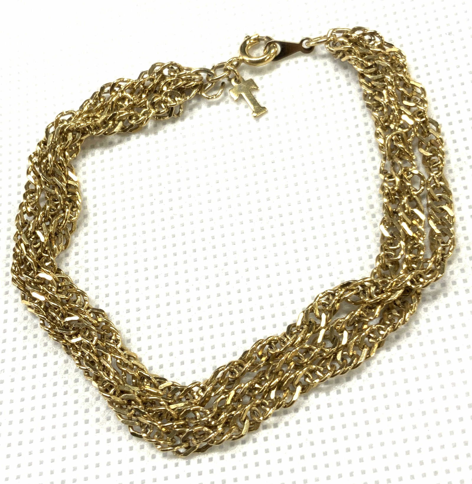 Triple Strand Gold Toned Bracelet: A gold toned bracelet, triple stranded with circular clasp. Initial T charm attached to the clasp. Approximately 7.15 inches long. Triple strand bracelet, bracelet, jewelry,Estate Jewelry, Costume Jew
