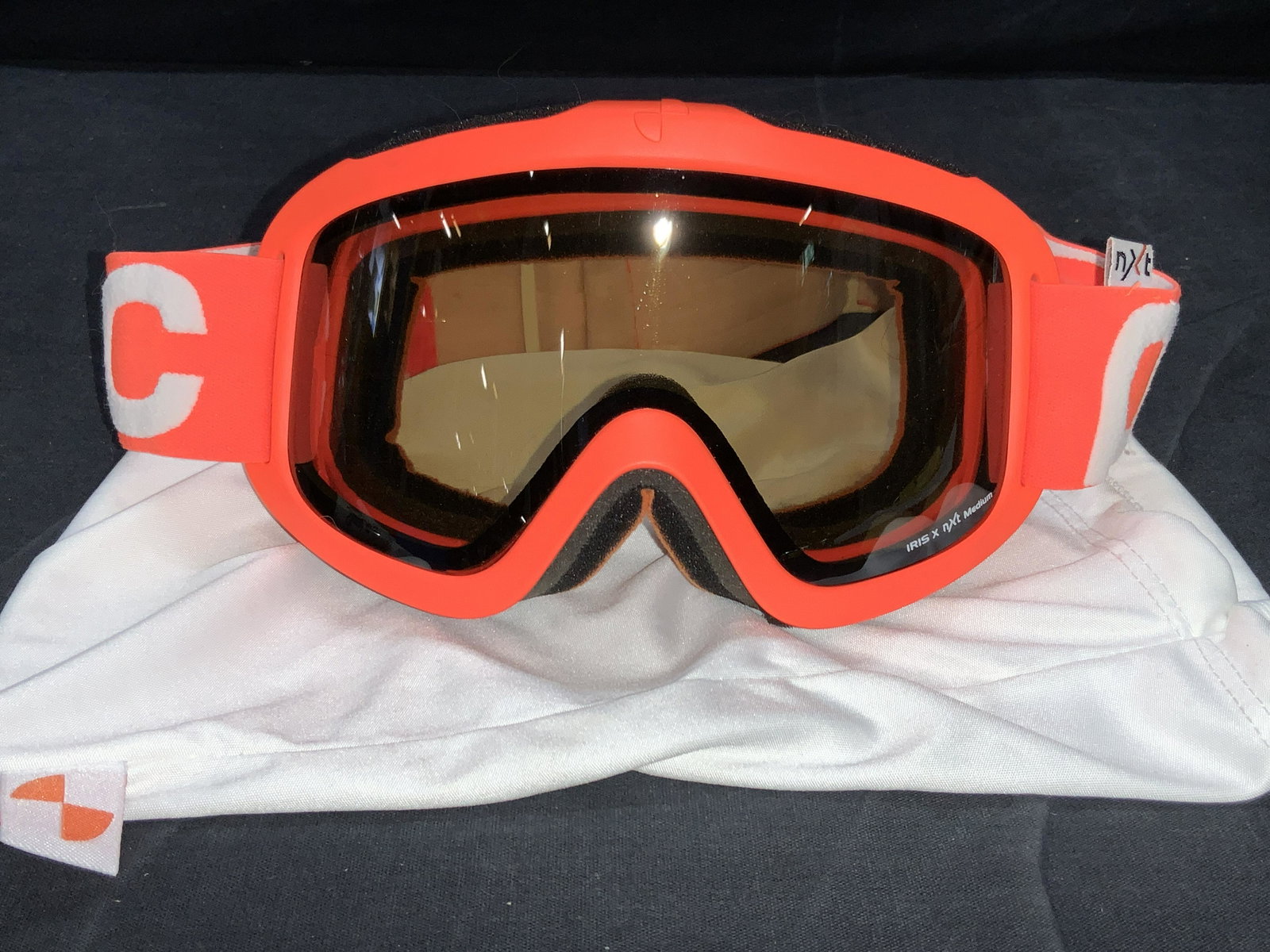 NXT Orange Medium Snow Sport Goggles: A pair of orange tone NXT brand snow sport goggles. Possibly never worn. Comes with white pouch with NXT logo. Goggles read Iris X, NXT Medium. With adjustable head strap. Approximately 7 inches Wide.